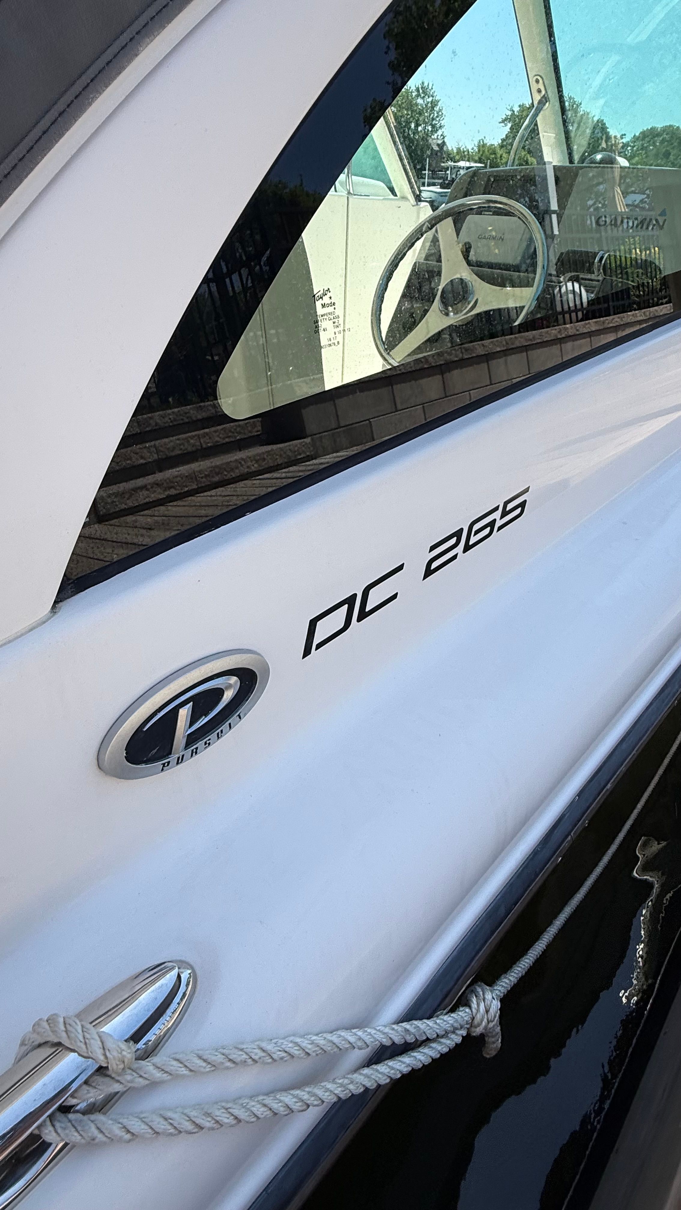 Close-up of a Pursuit DC 265 Dual Console boat with rope and logo.