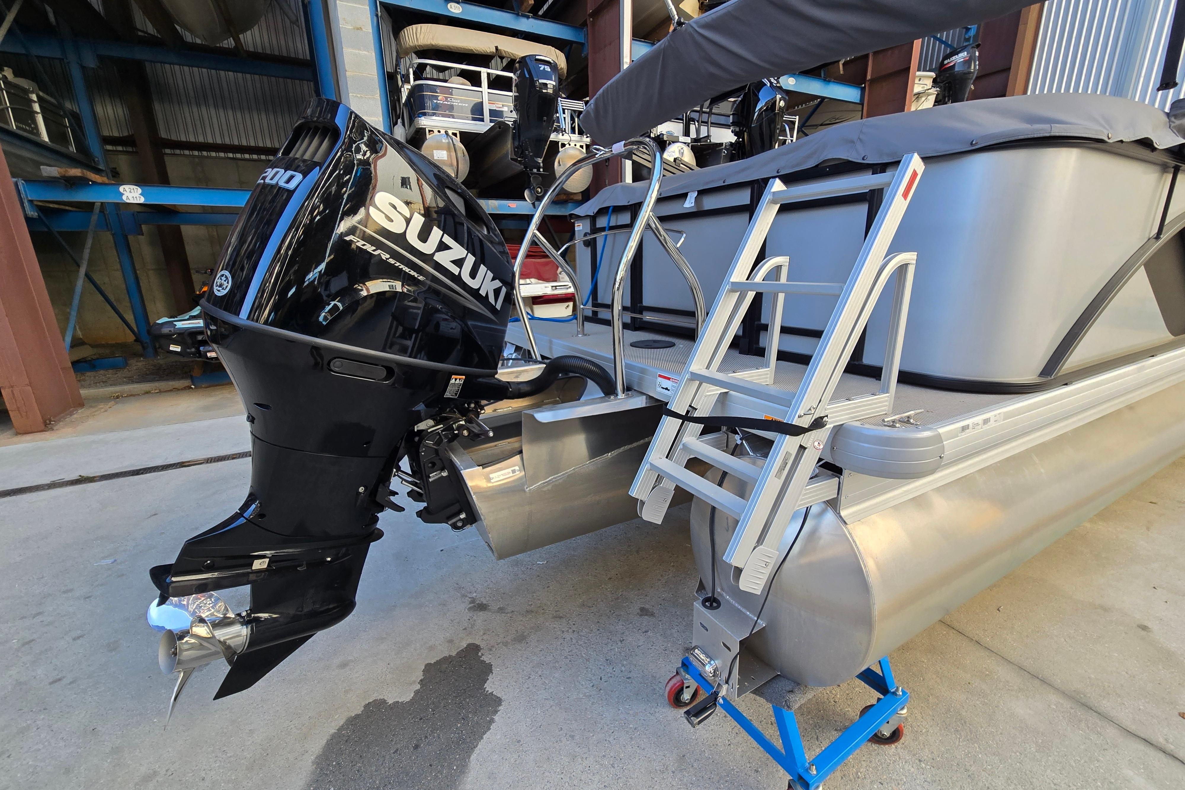 2024 Godfrey Sweetwater 2486 SB pontoon boat with Suzuki outboard motor and boarding ladder.