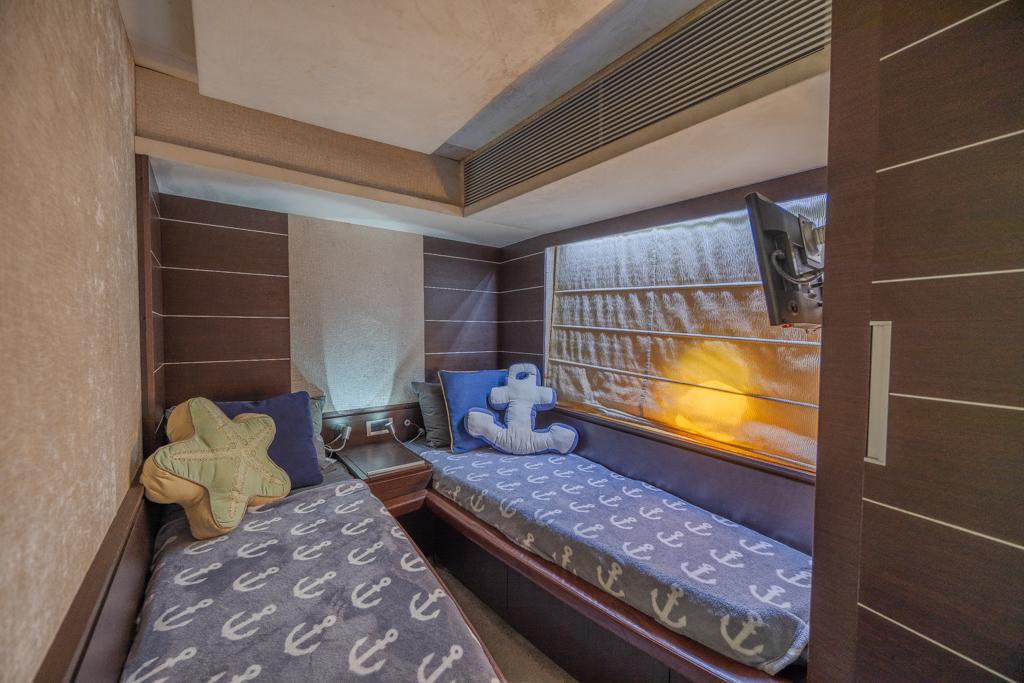 Cozy twin cabin in 2009 Azimut 68S yacht with nautical-themed decor.