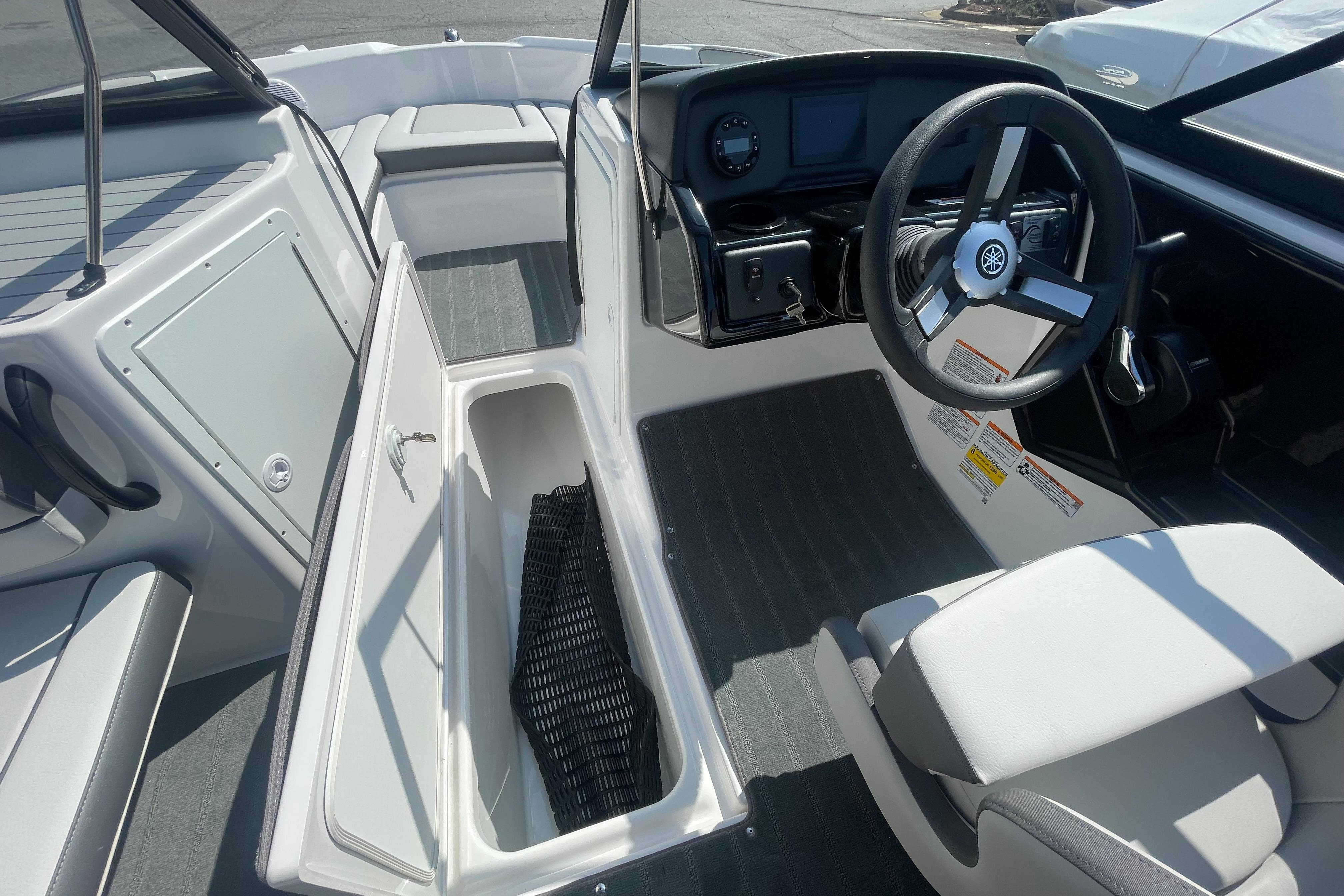 2026 Yamaha AR190 boat interior with open storage compartment and steering wheel.