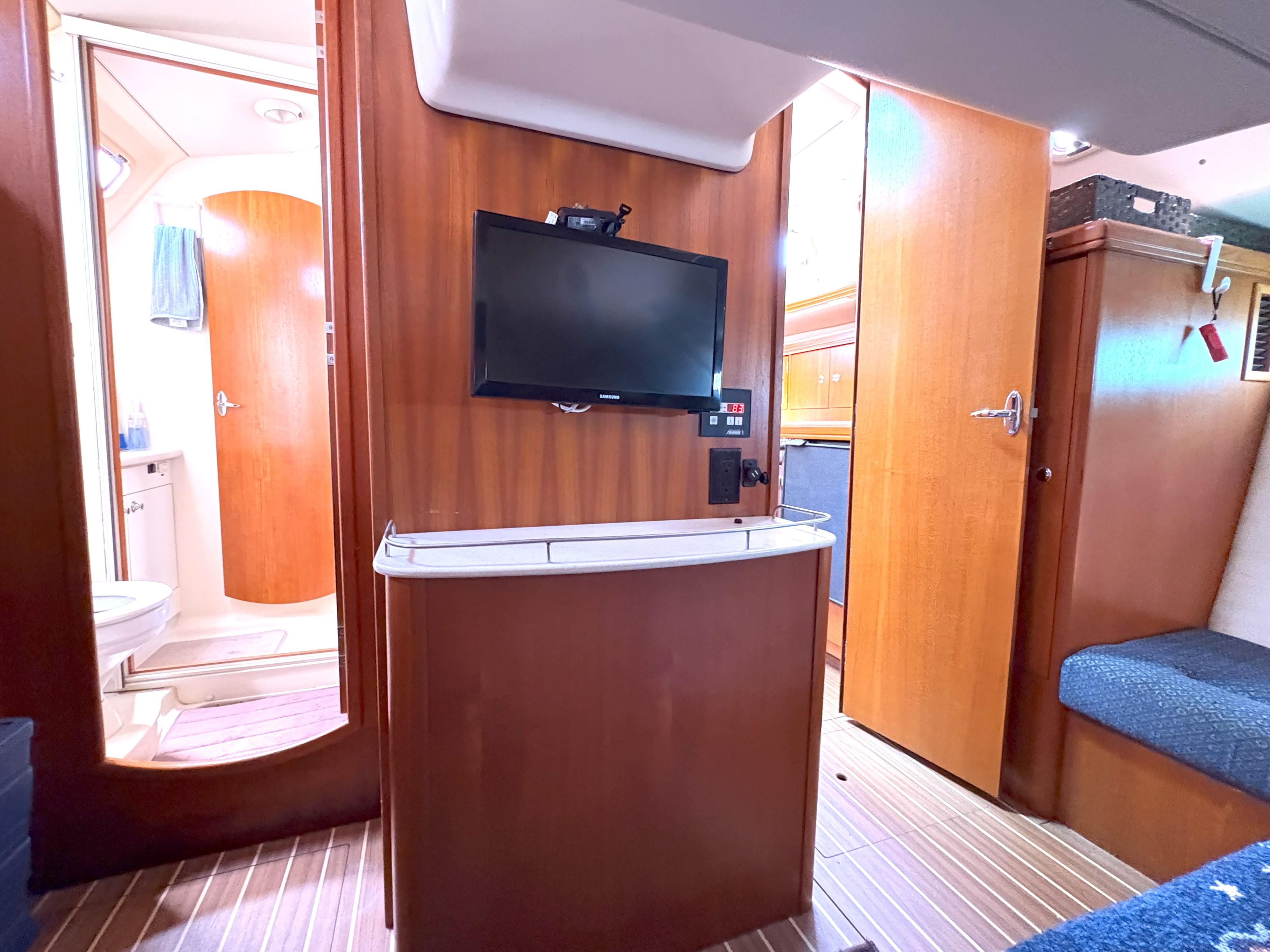 Interior of 2005 Hunter 38 yacht with TV, wooden cabinetry, and bathroom view.