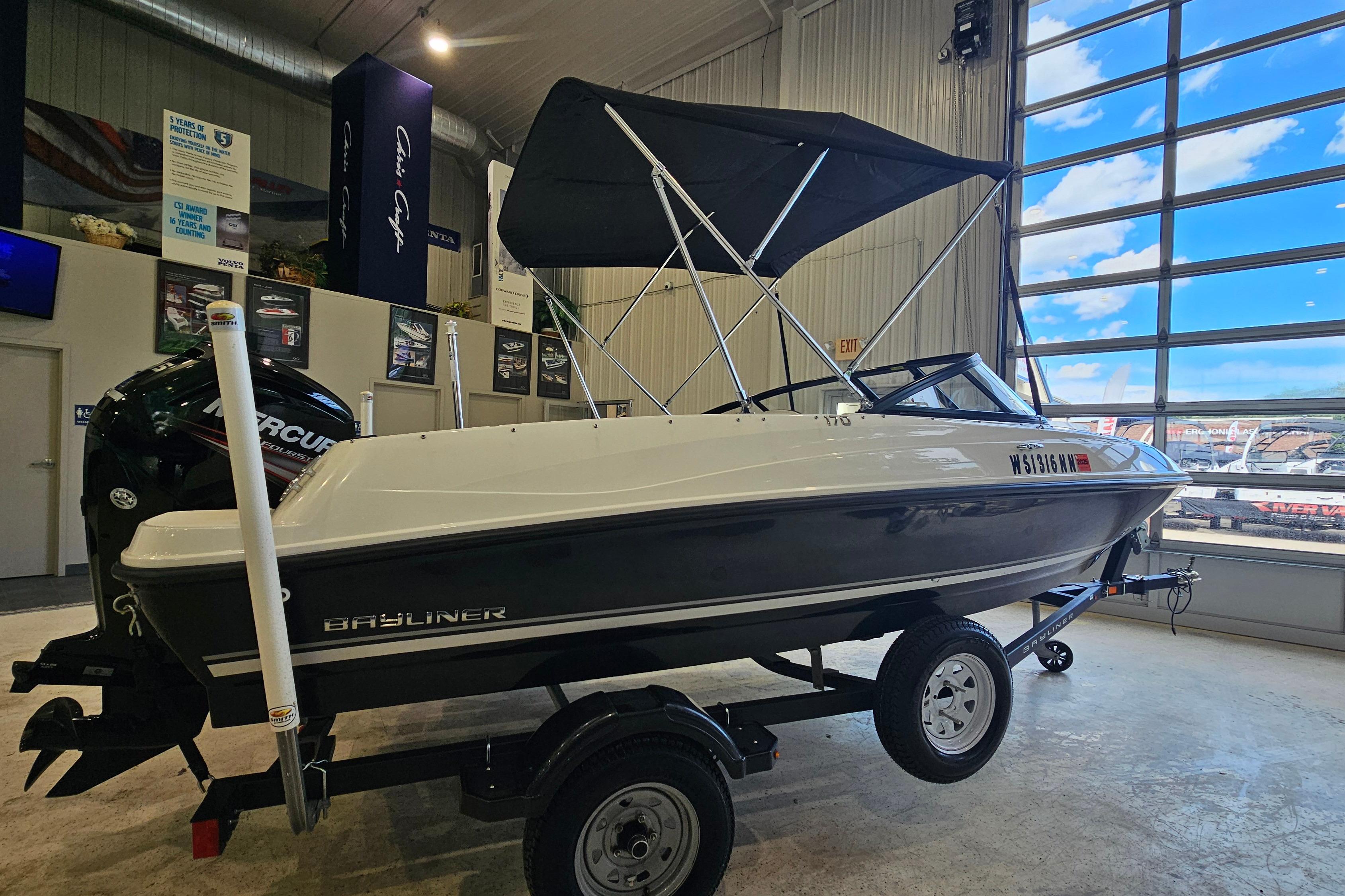 2019 Bayliner 170 Bowrider boat displayed indoors with a trailer and canopy.