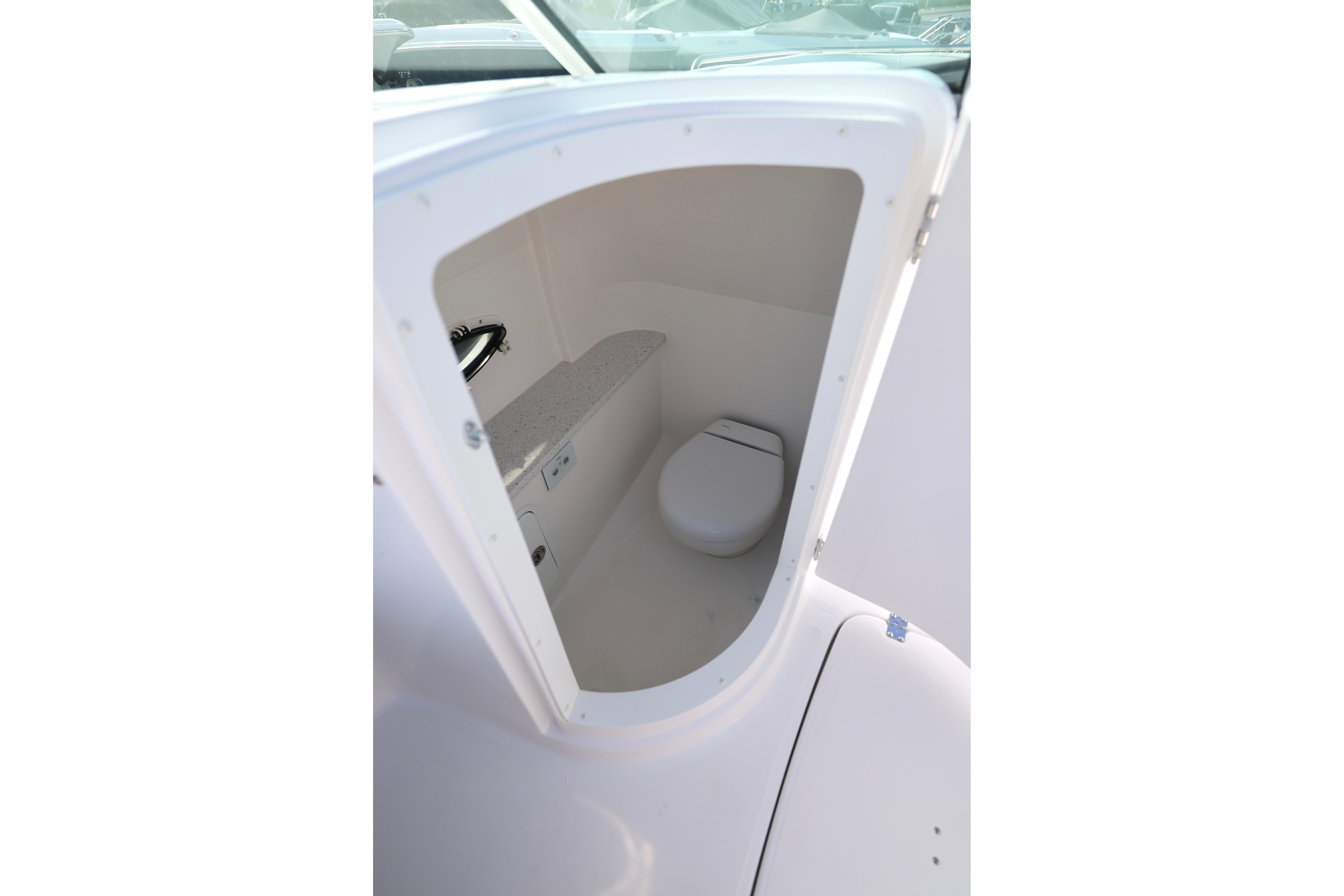 2026 Hurricane SunDeck 2486 OB boat interior with compact marine toilet.
