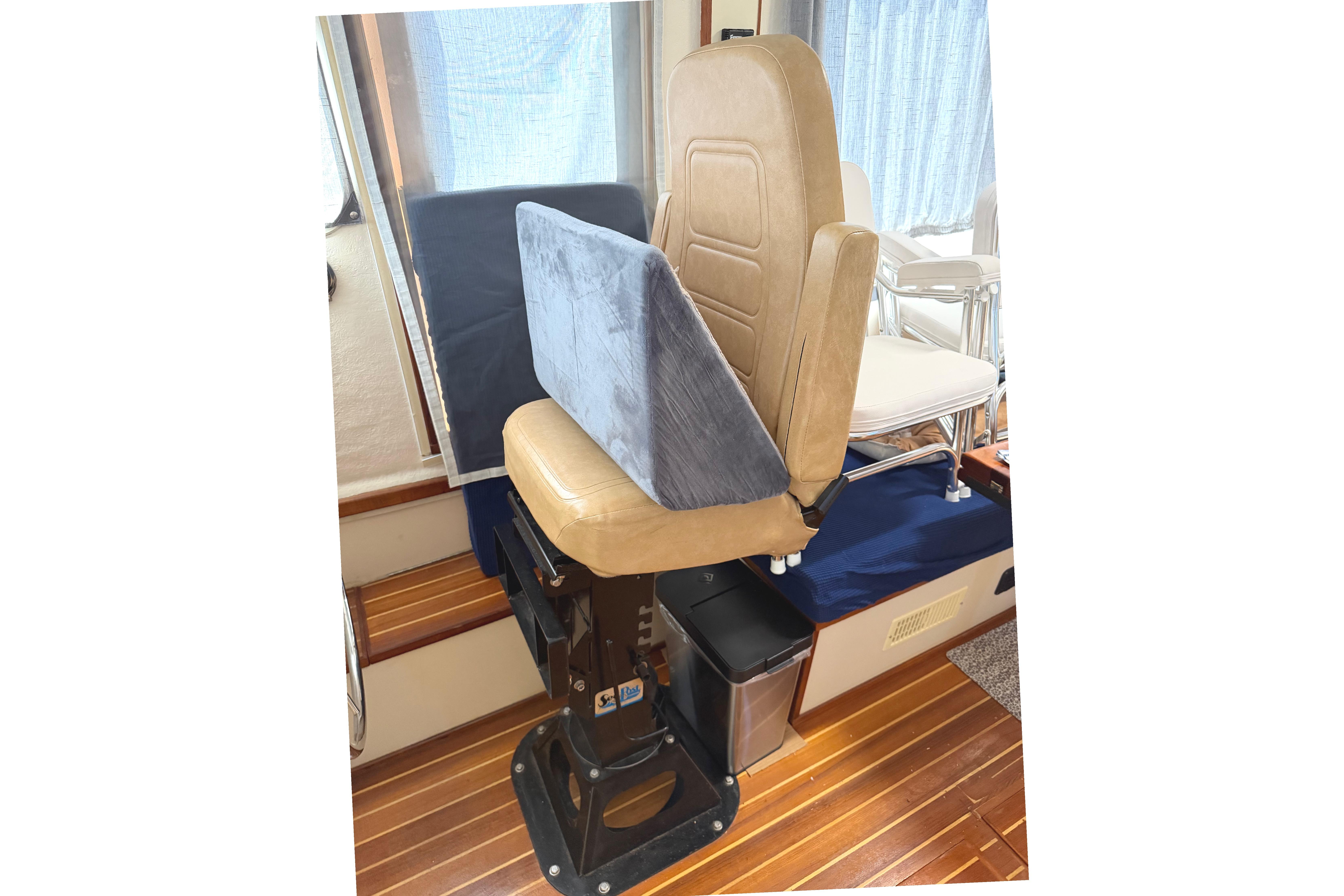 Captain's chair on 1997 Rosborough Trawler with wooden flooring and cushioned seating.
