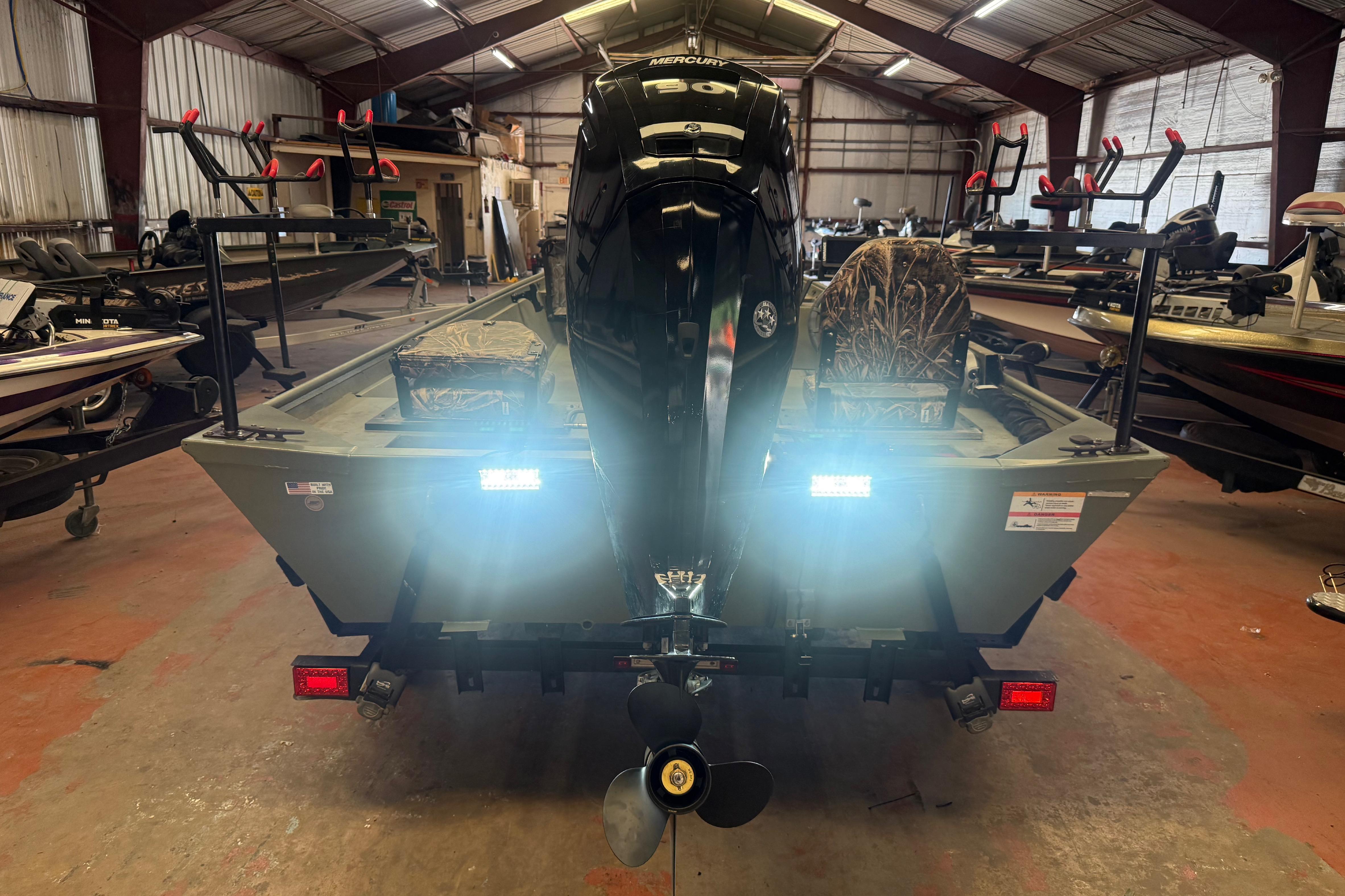 2020 Lowe Roughneck 2070 Big River boat in a warehouse, rear view with motor.