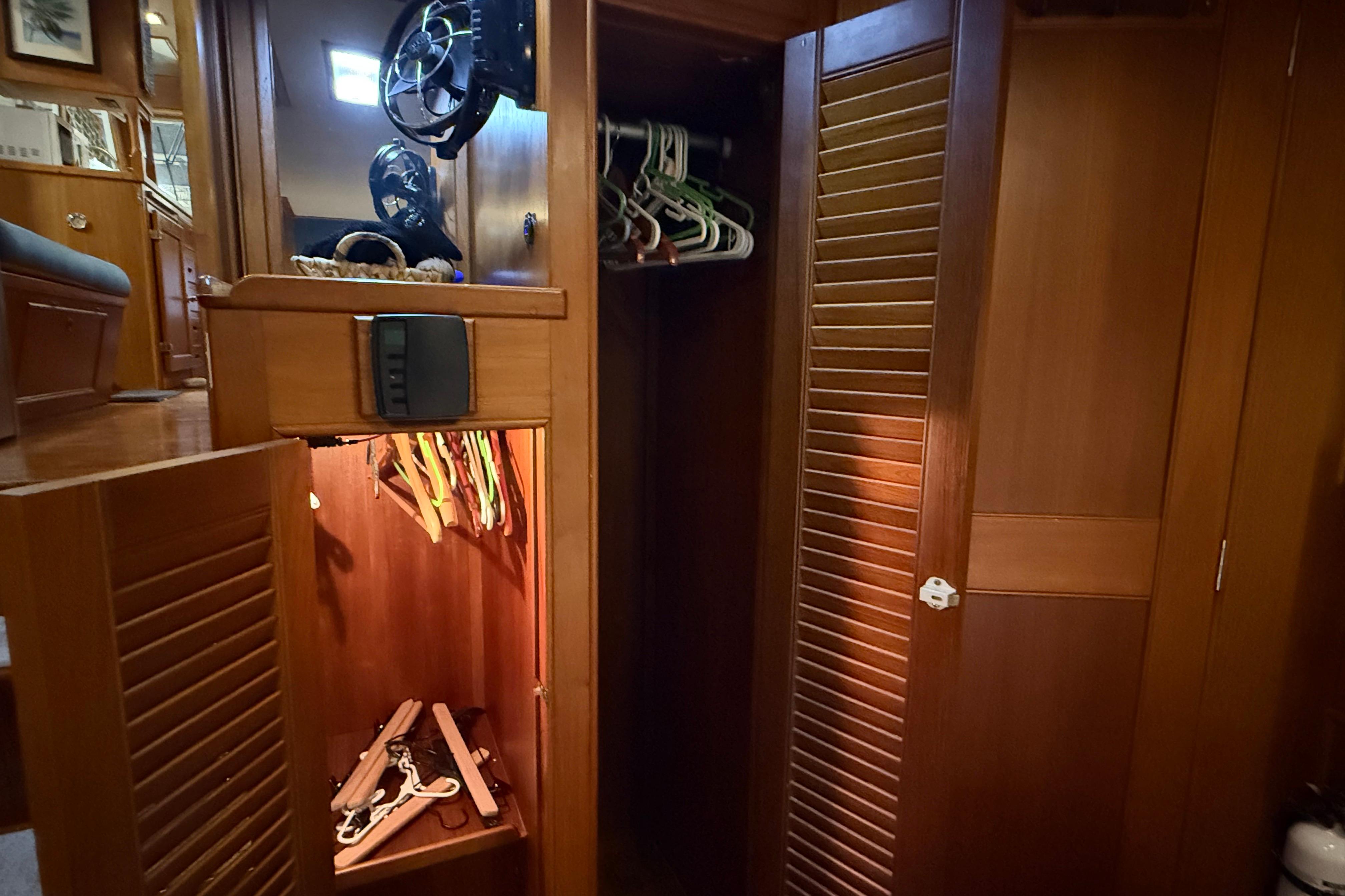 Wooden interior of 1991 Grand Banks 42 Classic yacht with open closet and hangers.