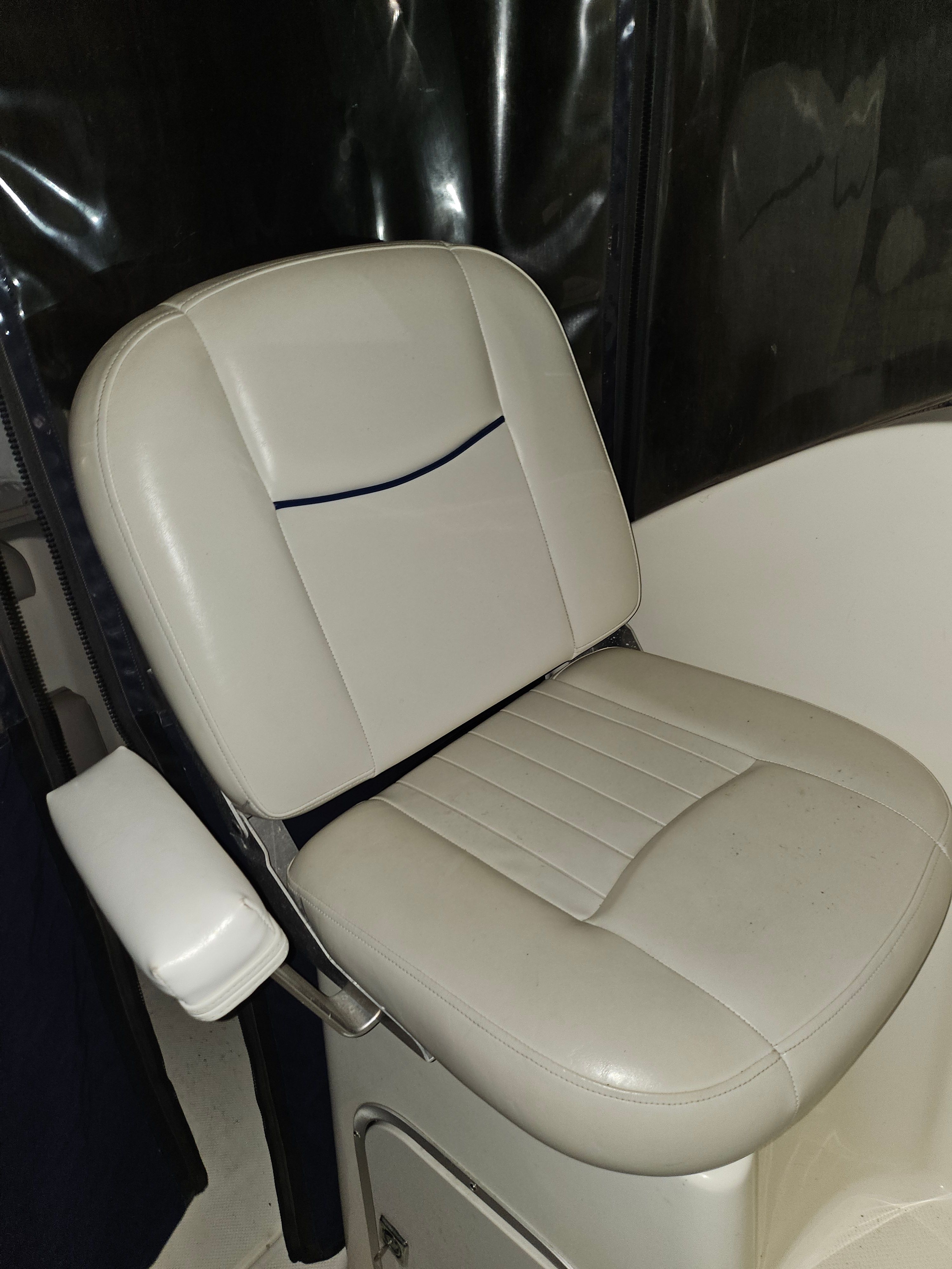 A white boat seat with blue trim in a 2005 Bayliner 242 Ceara.