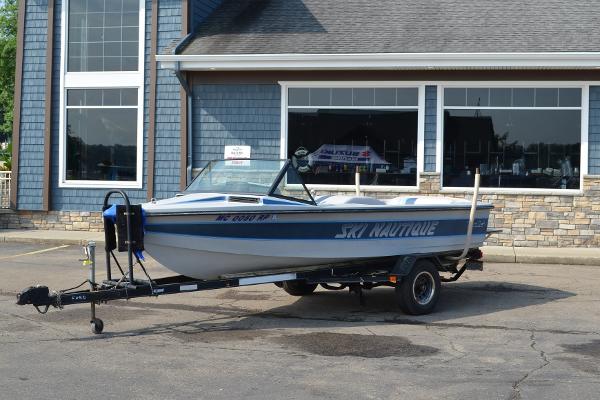 1989 Correct Craft Ski Nautique boat on trailer, parked outside a building.