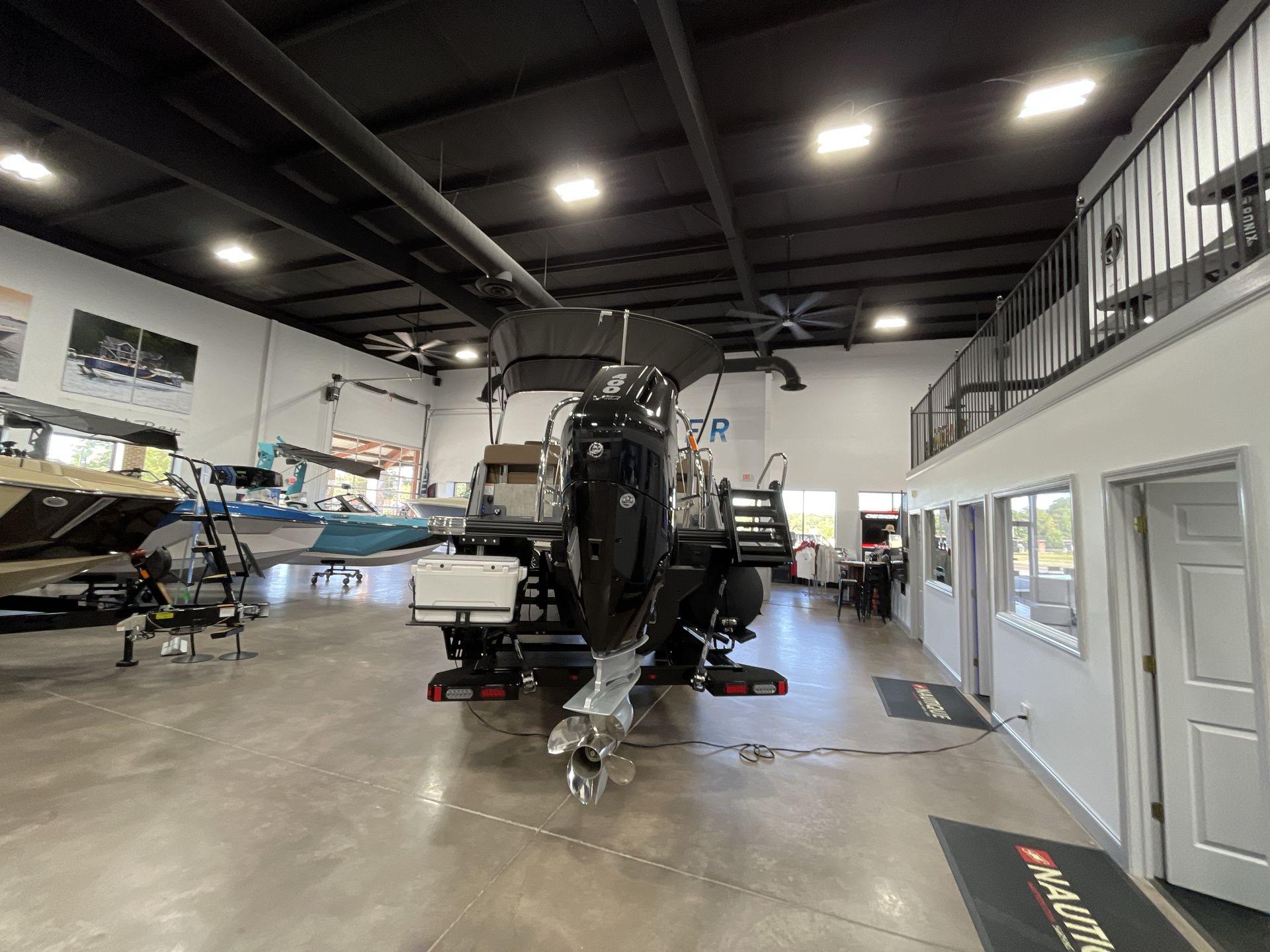 Indoor showroom displaying a 2025 Balise Horizon 26C boat with modern design.