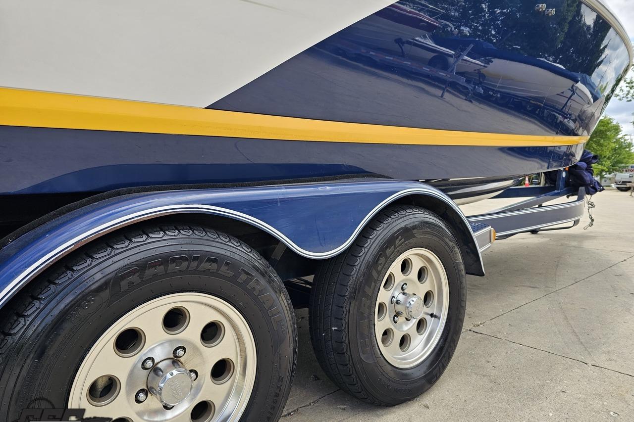 2010 Cobalt 232 WSS boat on trailer, featuring dual radial tires and sleek blue design.