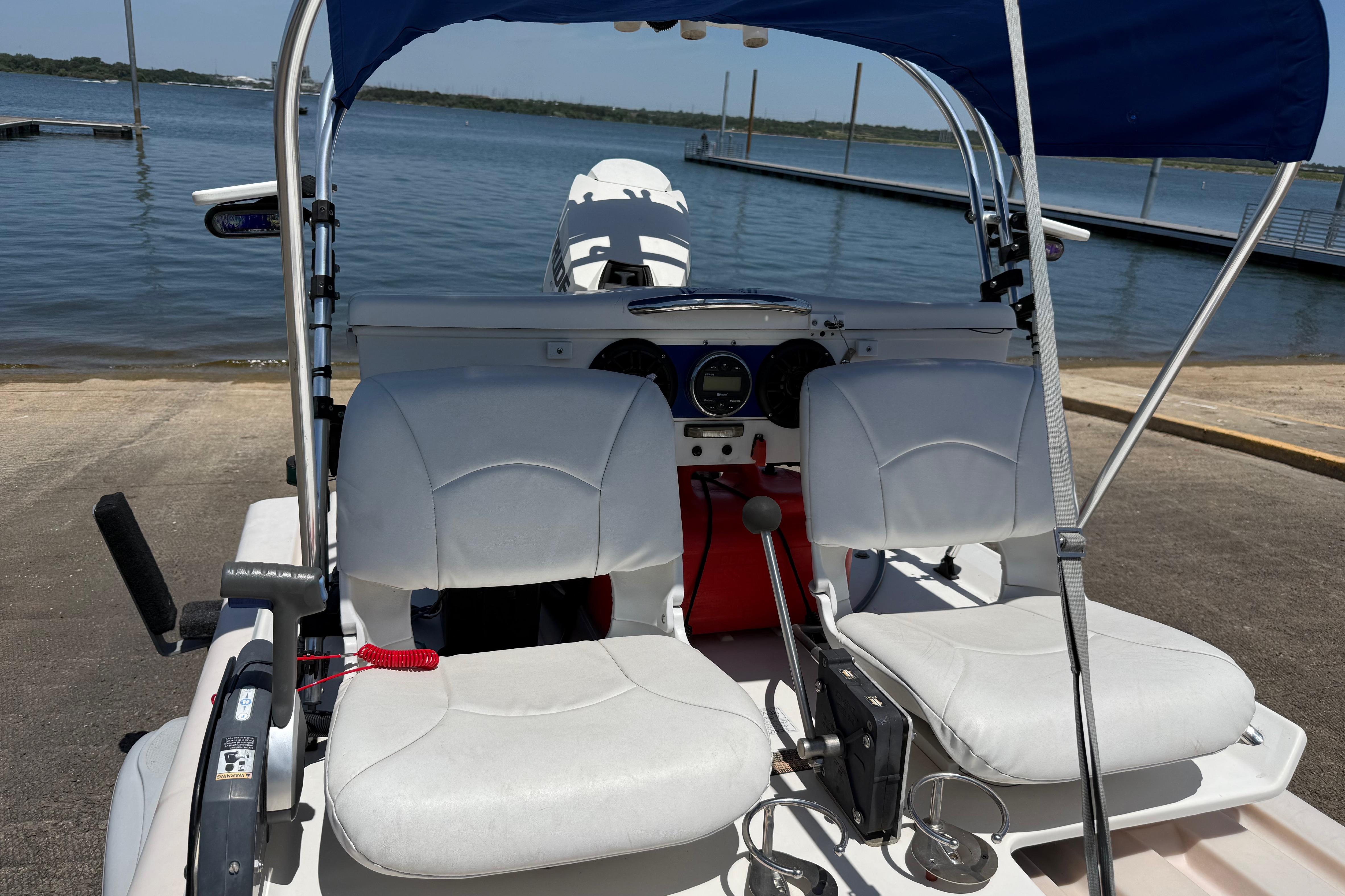 2016 CraigCat E2 Elite with dual seats and canopy, docked by a serene lake.