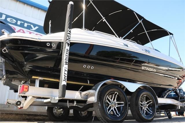 A black 2022 Stingray 212 SC boat on a trailer with a sunshade.
