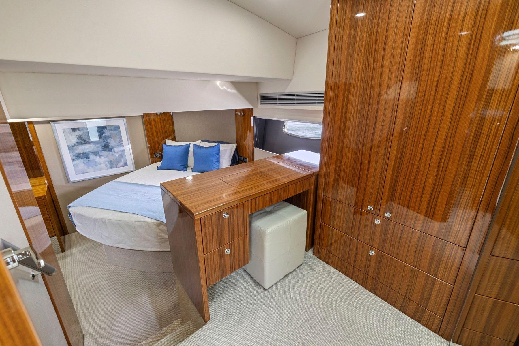 Luxurious 2014 Maritimo M50 yacht cabin with elegant wood finish and cozy bedding.