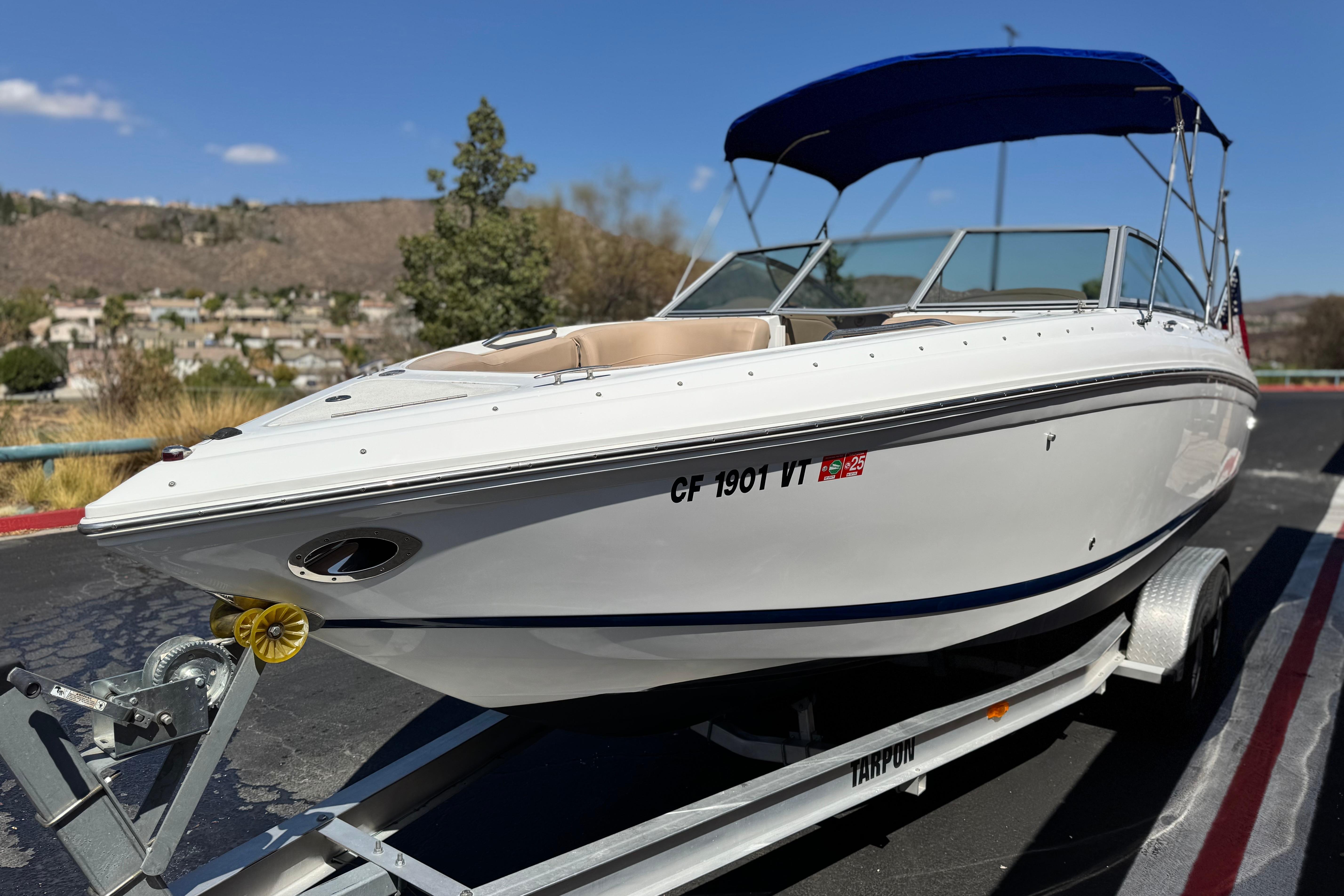 2008 Cobalt 262 boat on trailer with blue canopy, parked outdoors.