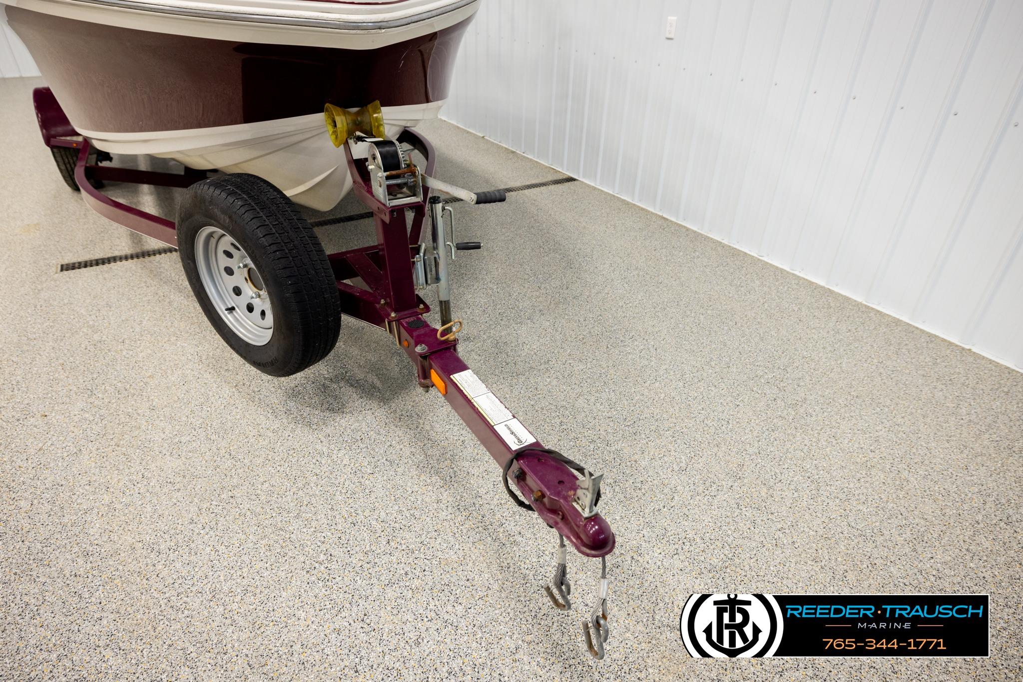 2016 Tahoe 450 TS boat trailer in a showroom with contact details.