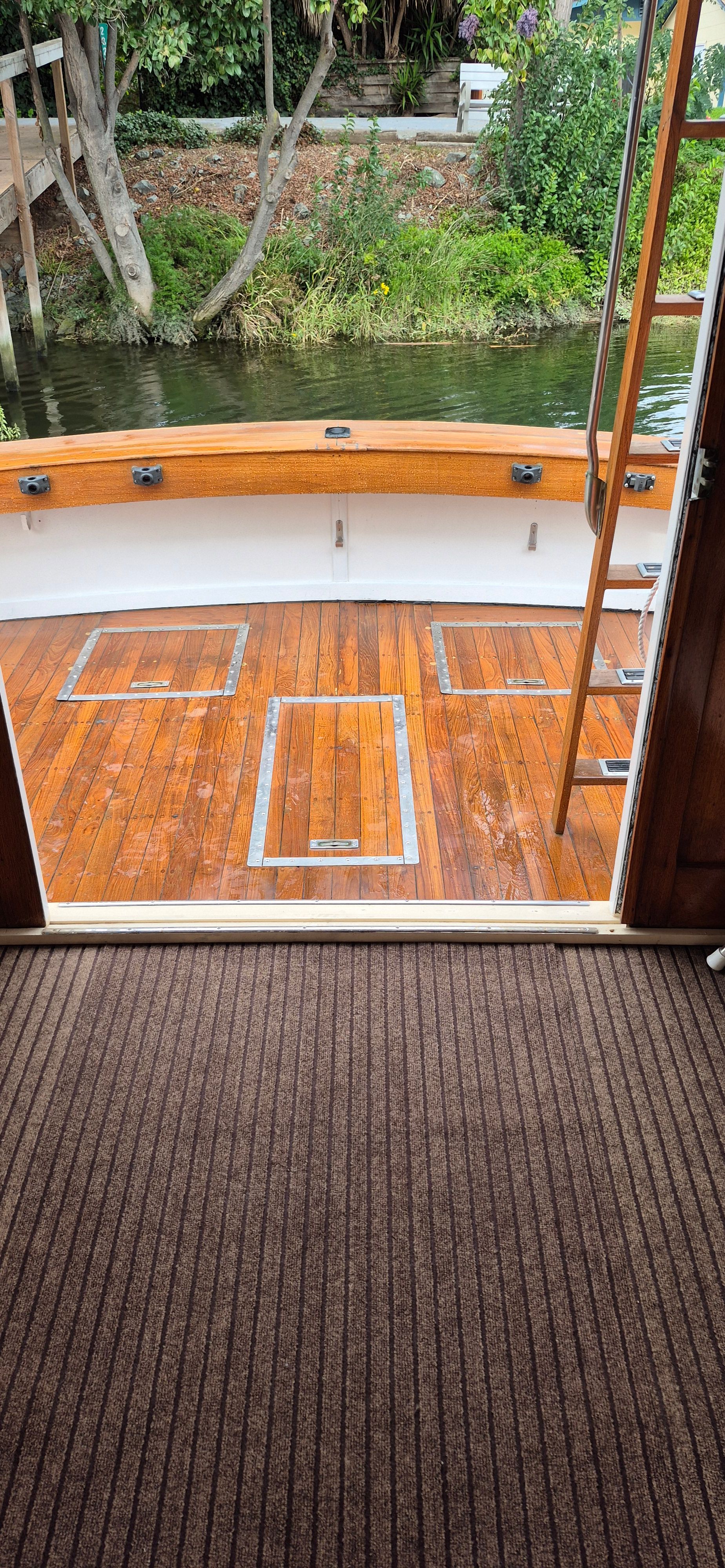 Deck of a 1976 Egg Harbor 33 Sportfisher boat by the water.