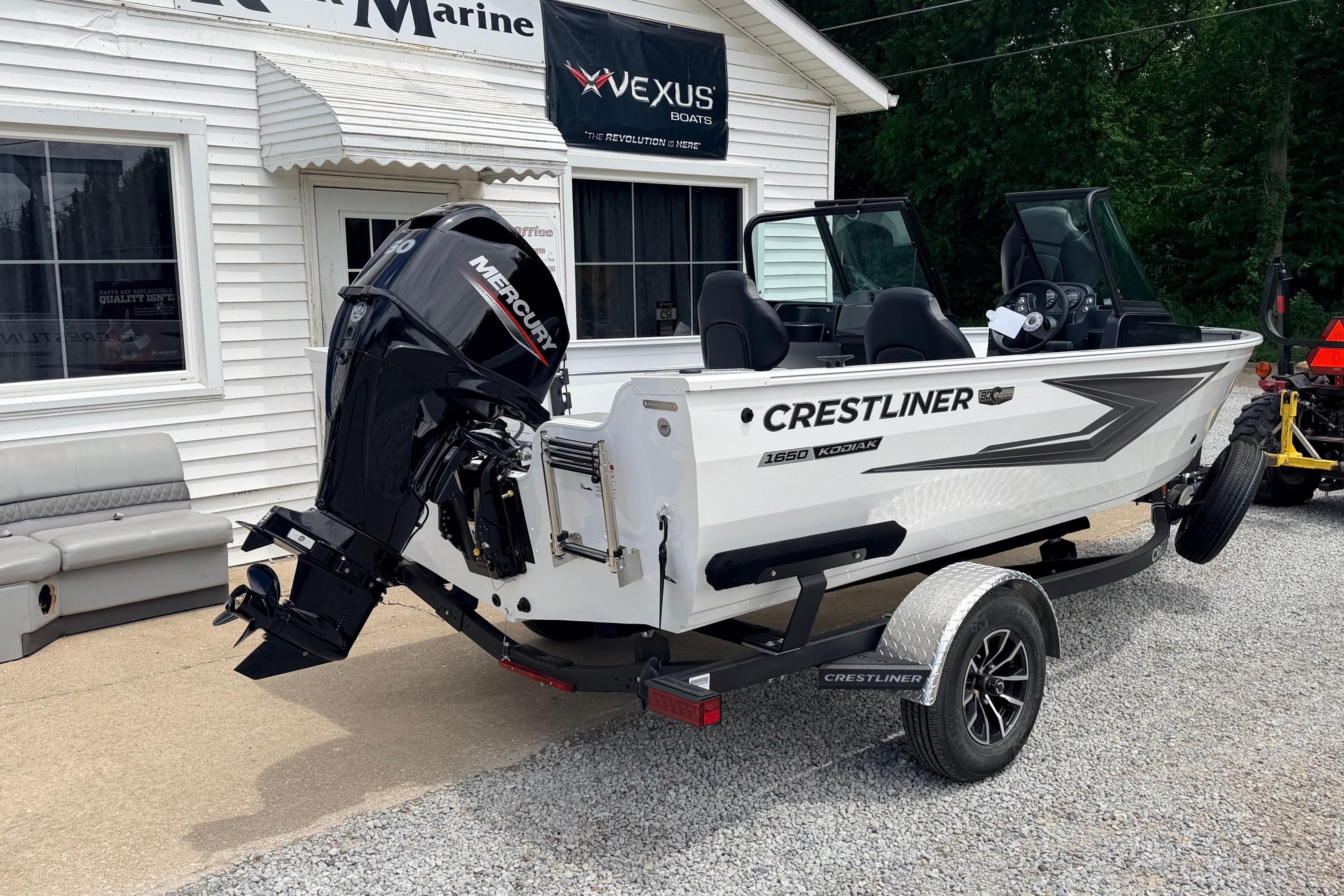 2026 Crestliner 1650 Kodiak WT boat with Mercury engine on trailer outside dealership.