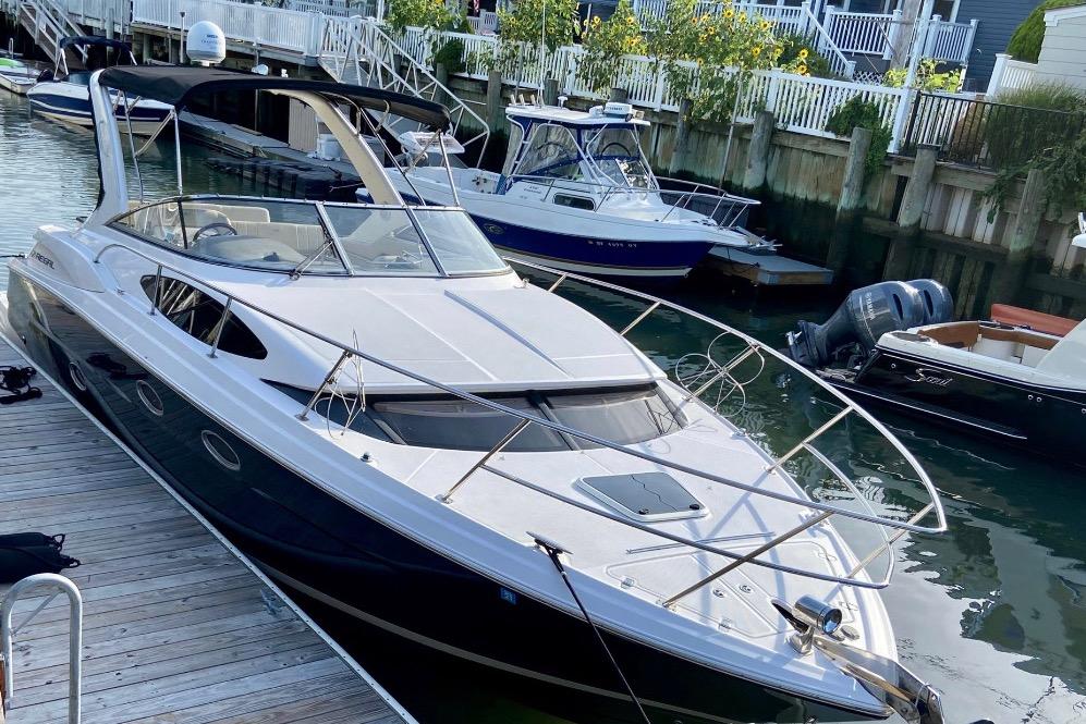 2012 Regal 35 Express Cruiser docked at marina, surrounded by other boats.