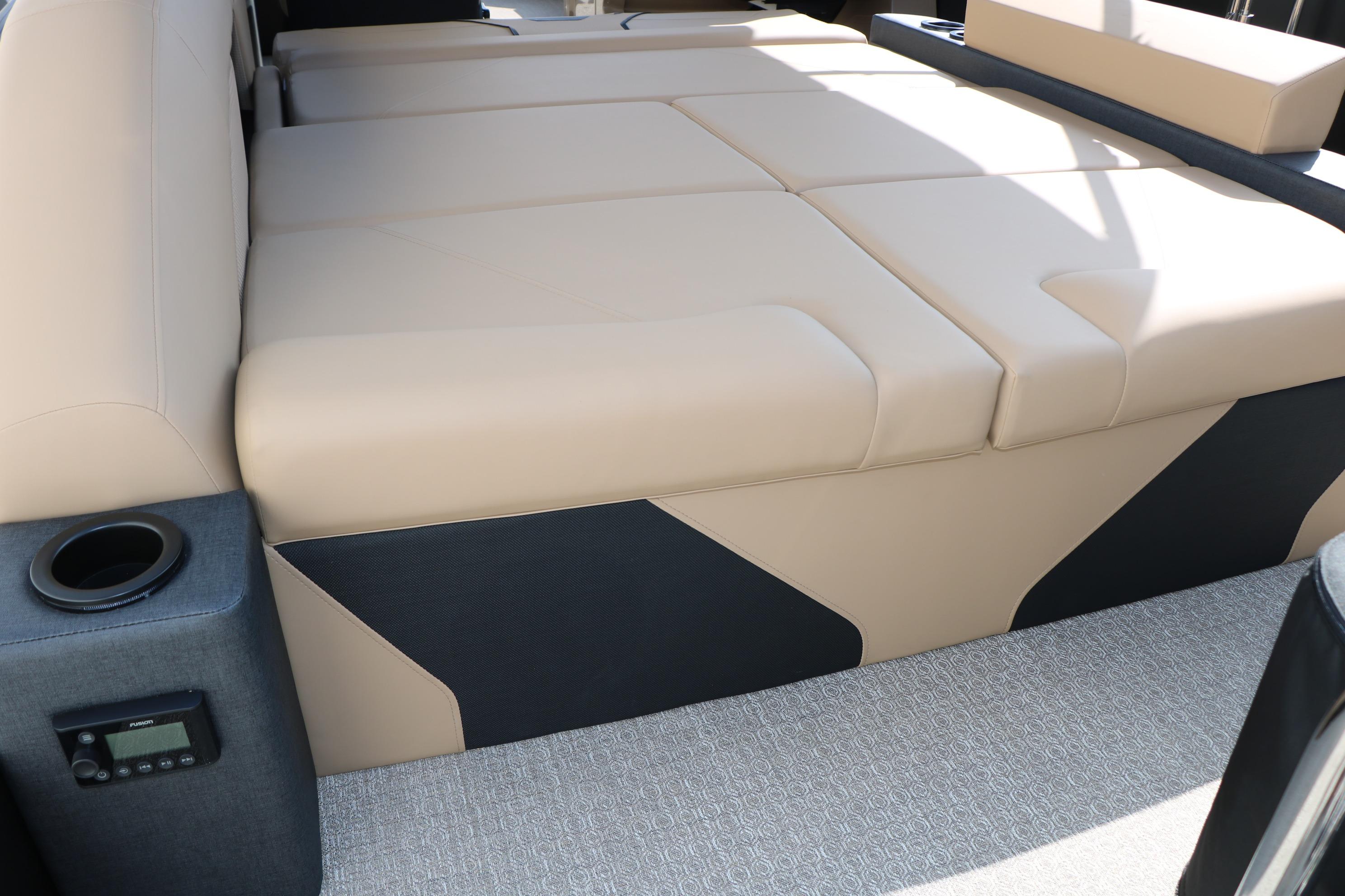 Luxurious beige seating in 2026 Evotti 723CS boat interior with cup holder and control panel.