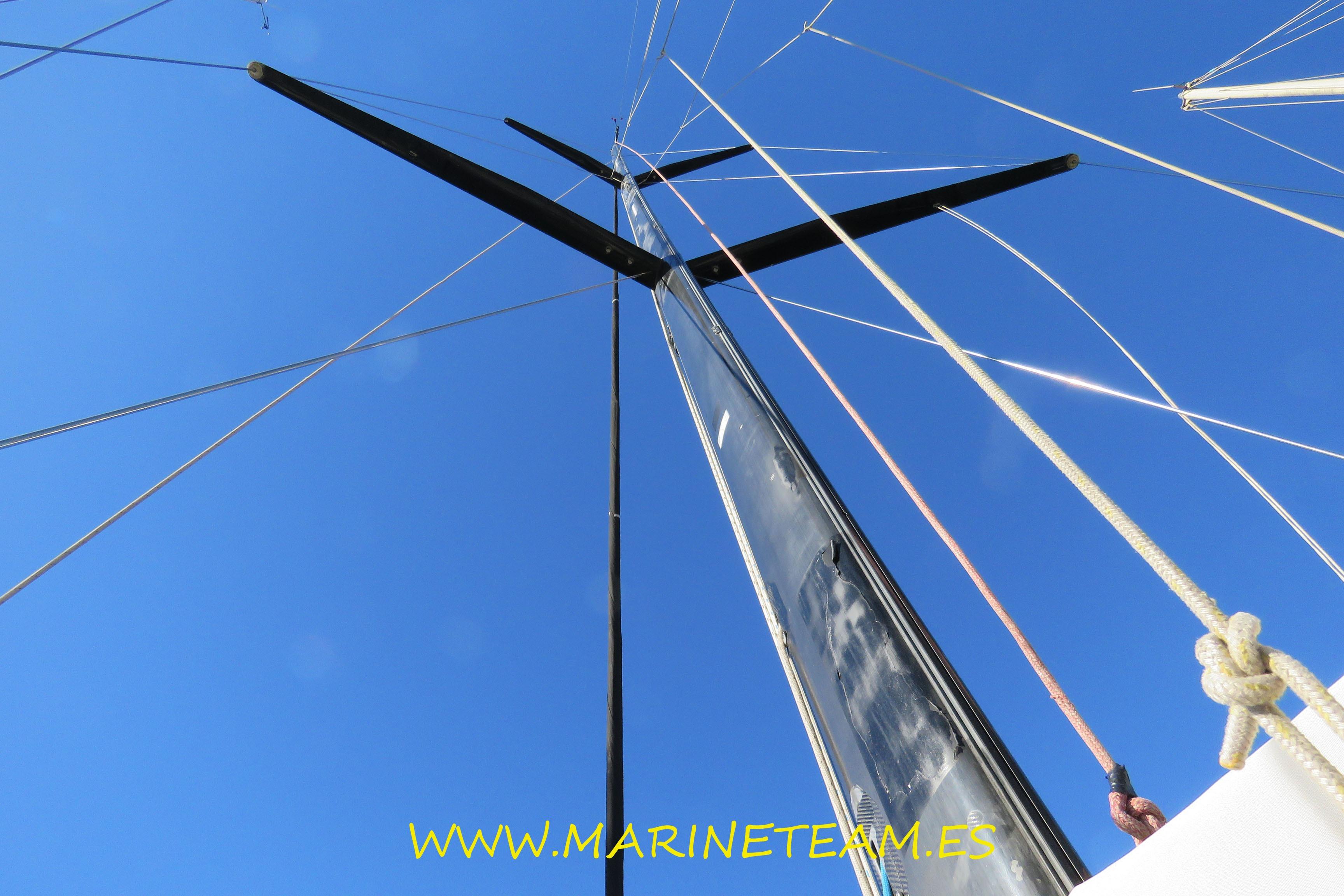 Tall mast of a 2005 Shipman 50 sailboat against a clear blue sky.
