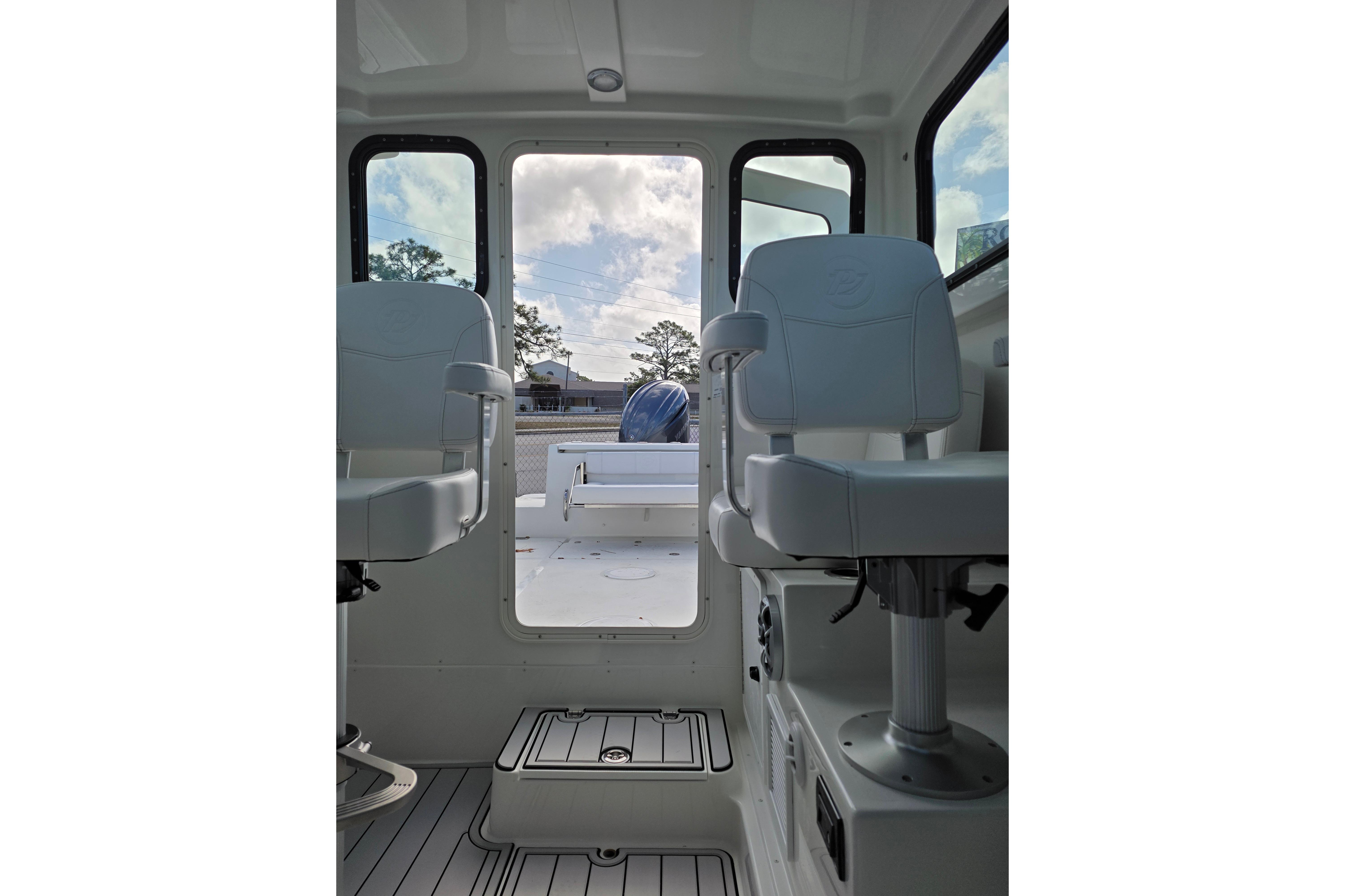 Interior view of 2026 Parker 227 Explorer boat, featuring two white seats and a rear door.