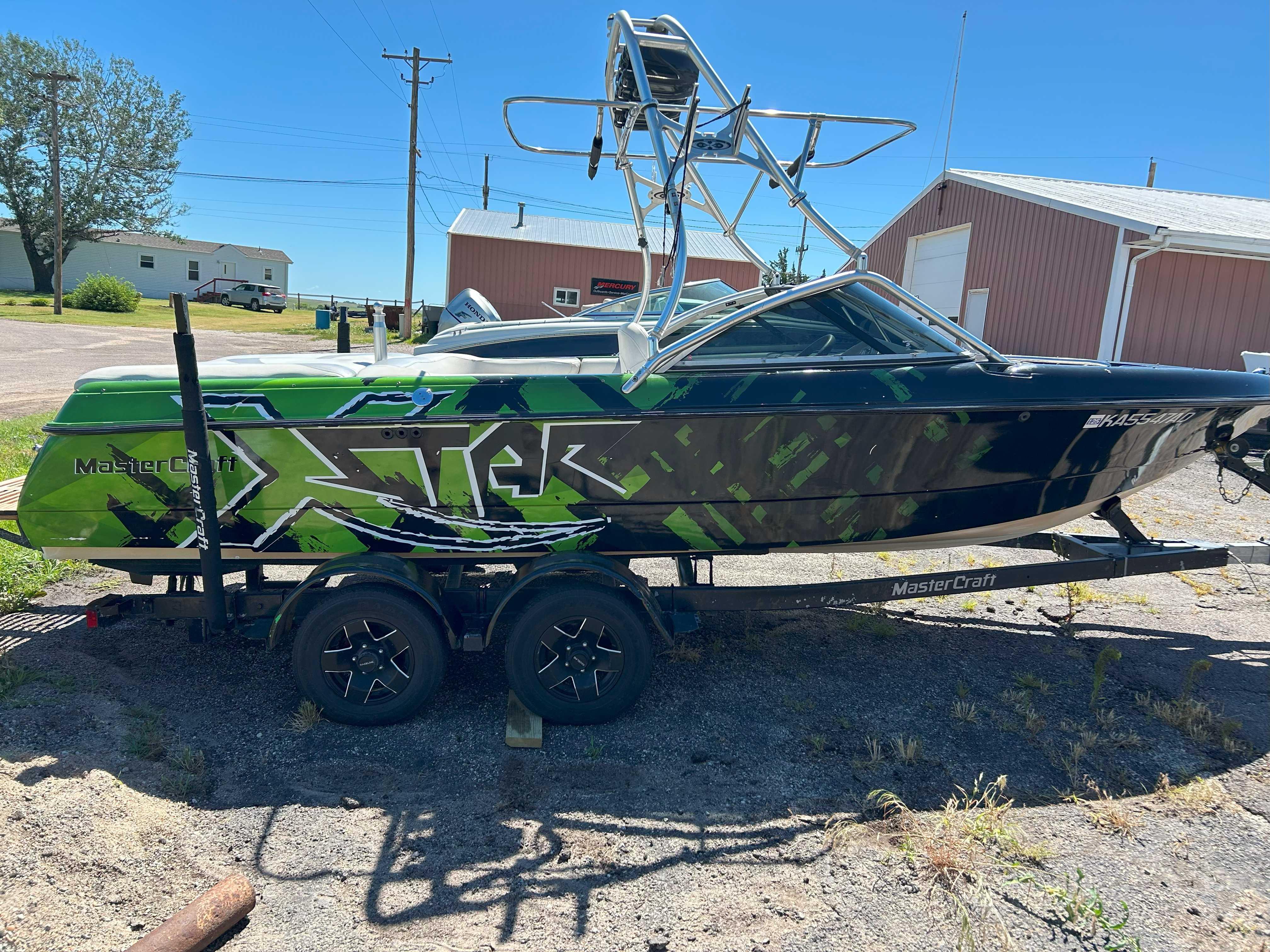 2002 MasterCraft XStar boat with green and black design on a trailer.