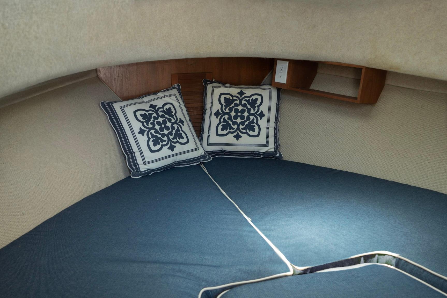 Cozy cabin interior of 2006 Atlas Boat Works Acadia 25 with decorative pillows.