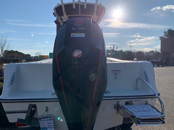 2024 Mako 214 CC boat with powerful outboard motor in a sunny outdoor setting.