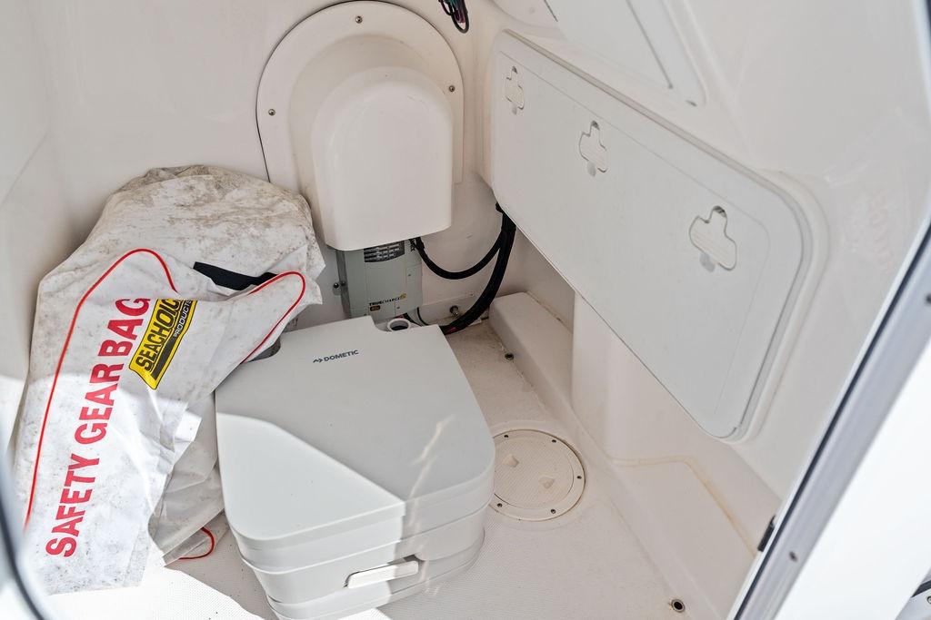 Interior of 2023 Everglades 243 Center Console with safety gear and portable toilet.