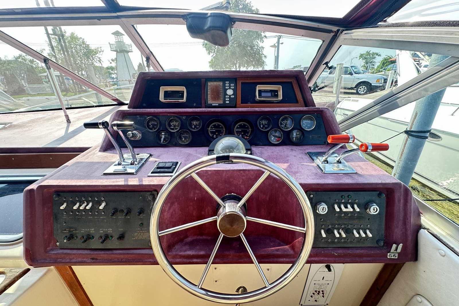 1987 Sea Ray 340 Sundancer helm with steering wheel, gauges, and controls.