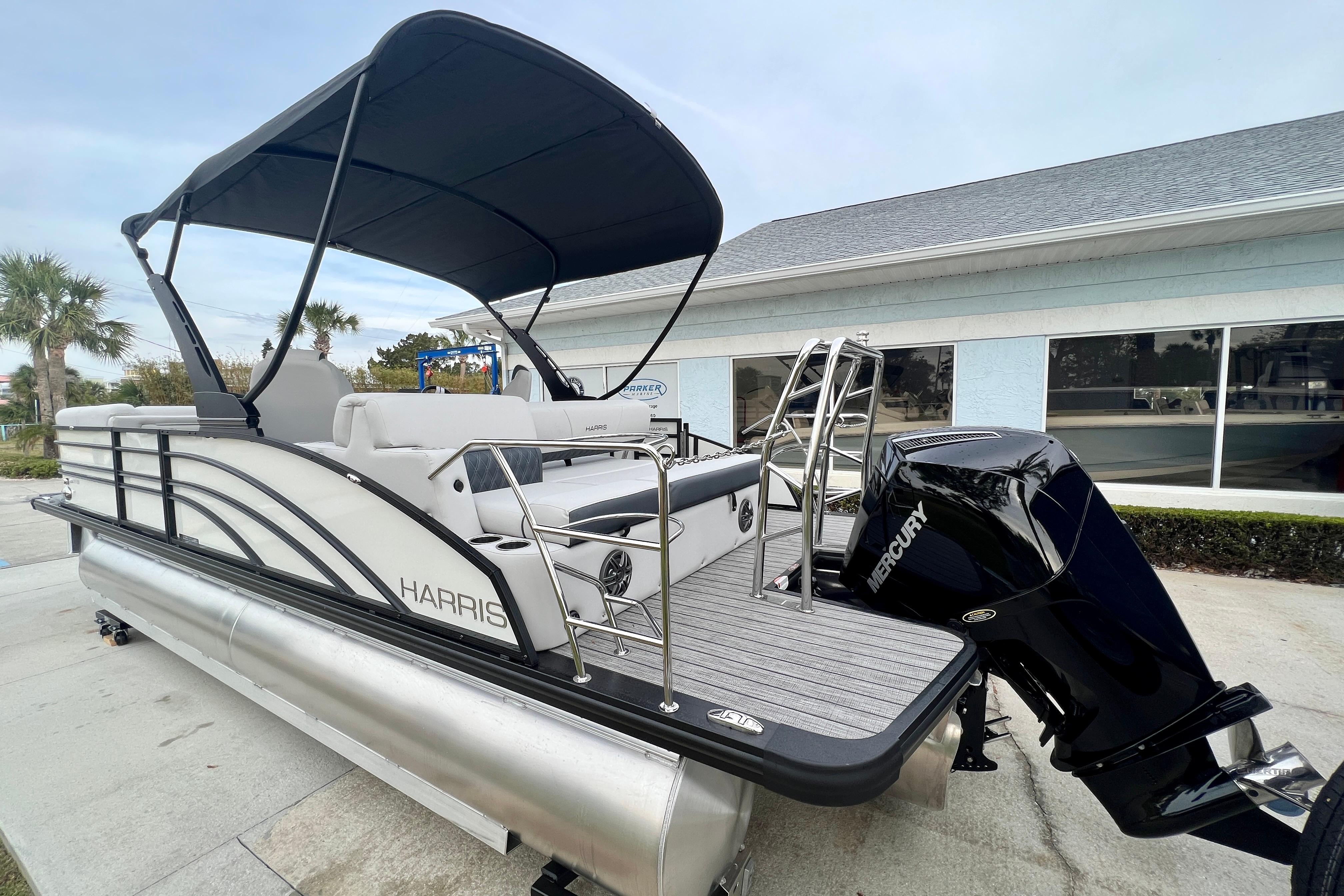 2025 Harris Sunliner 230 pontoon boat with Mercury engine, side view.