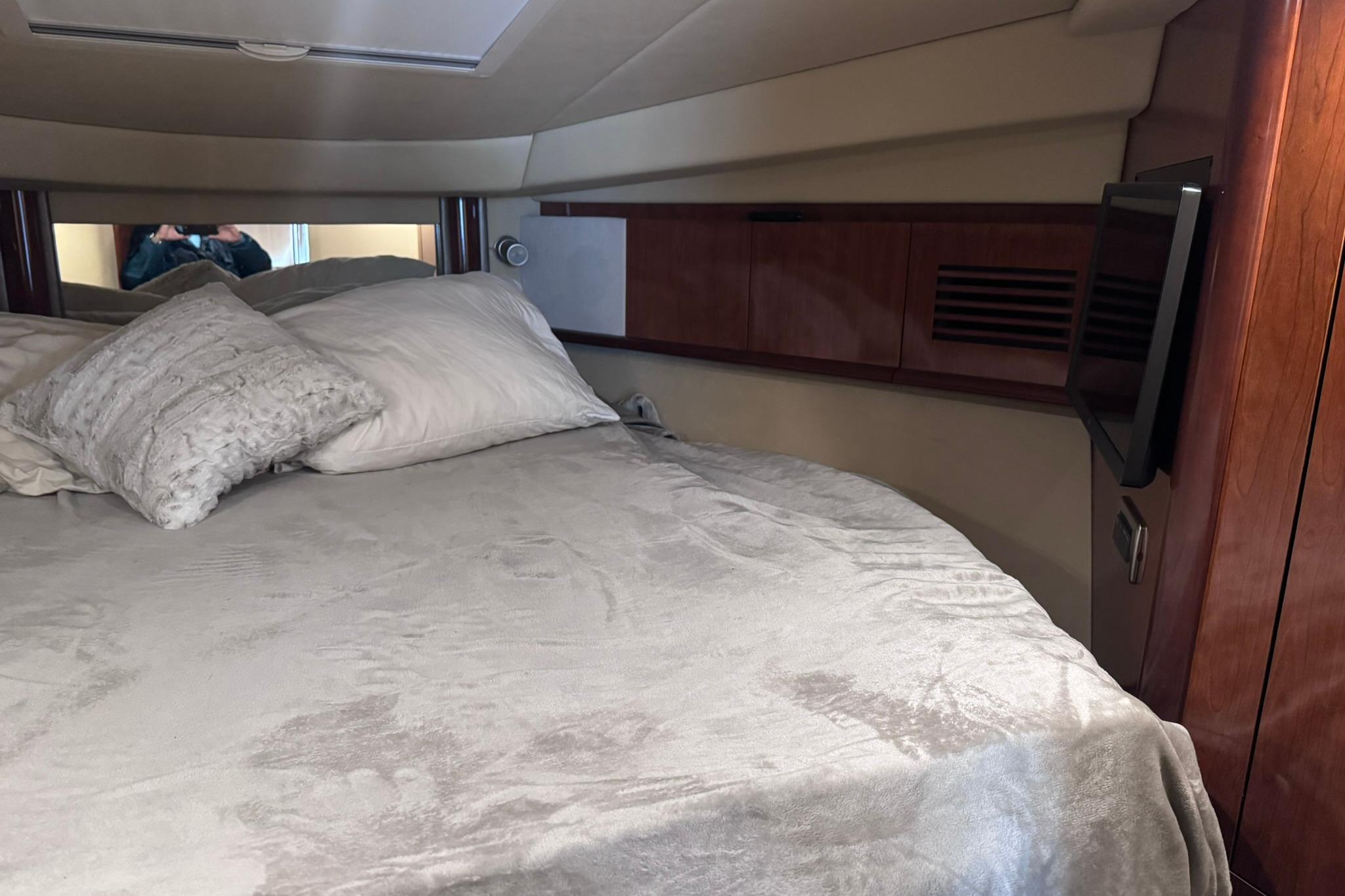 Luxurious cabin interior of 2004 Sea Ray 390 Sundancer with cozy bedding.