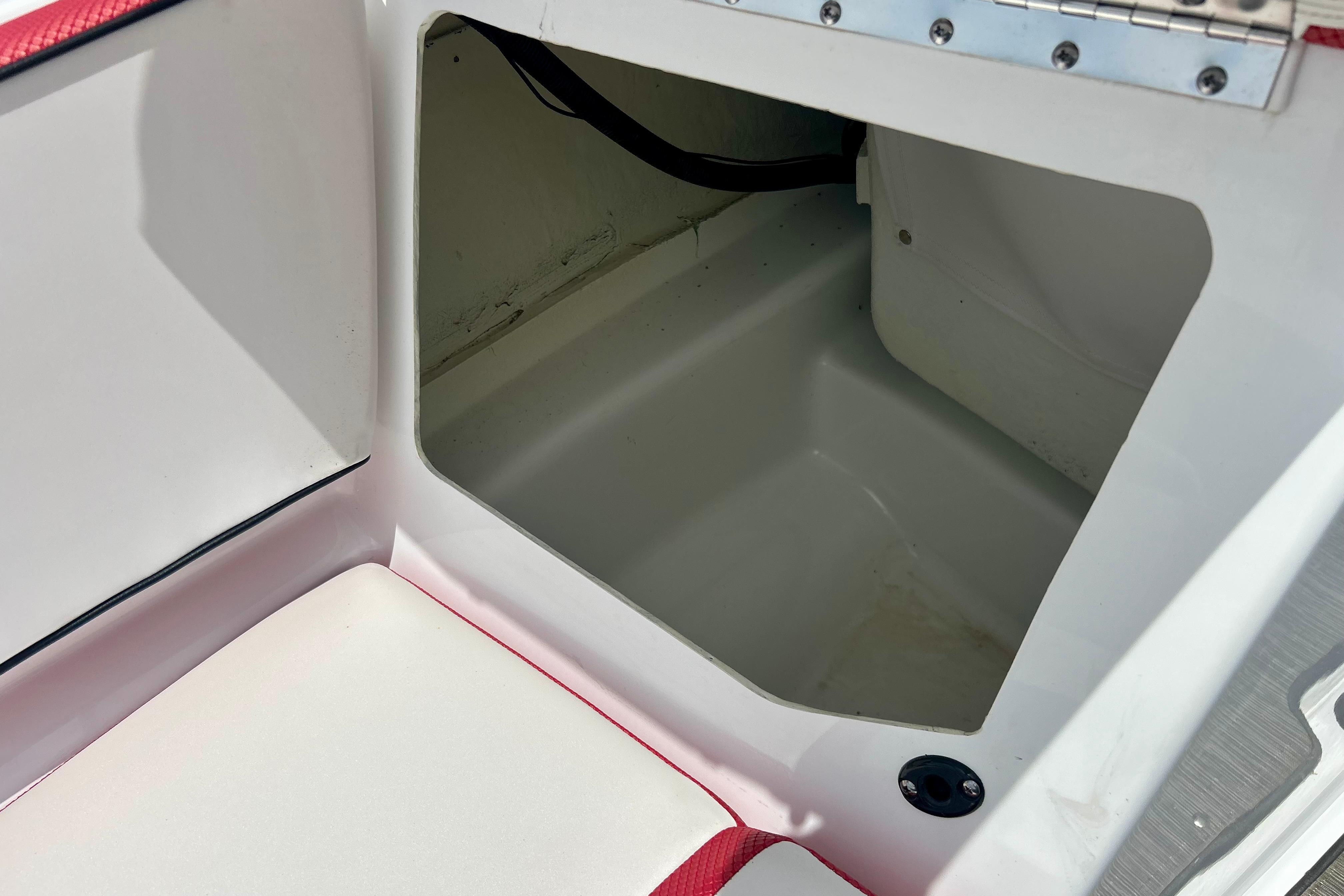 Storage compartment in 2021 Scarab 195 ID boat, featuring white and red interior.