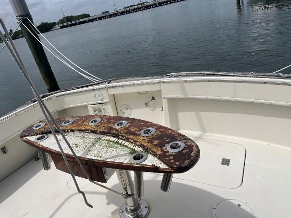 1985 Hatteras 45 Convertible fishing deck with rod holders, overlooking calm waters.