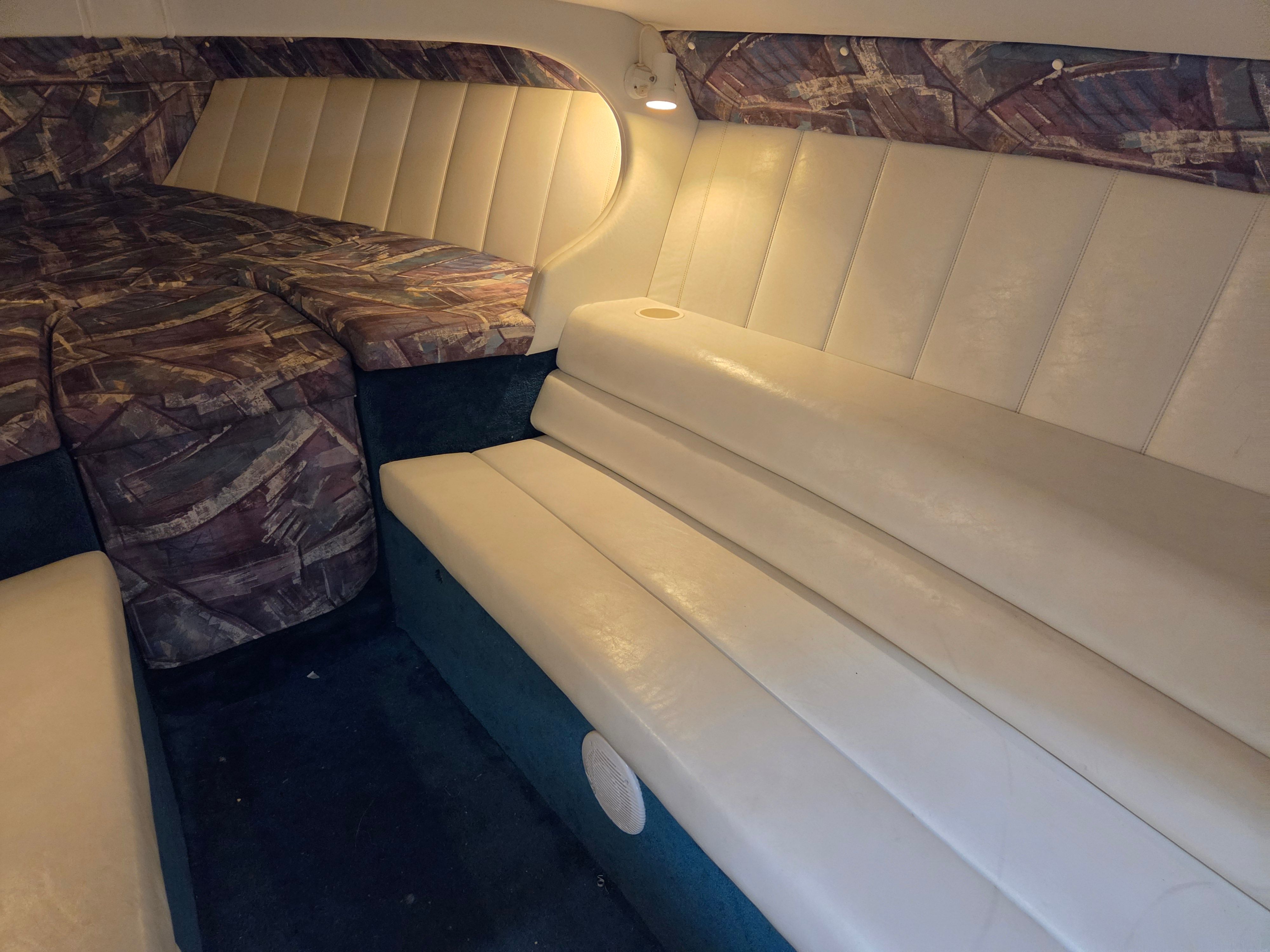 Interior of a 1998 Powerquest Enticer 290 FX with cushioned seating and a lounging area.