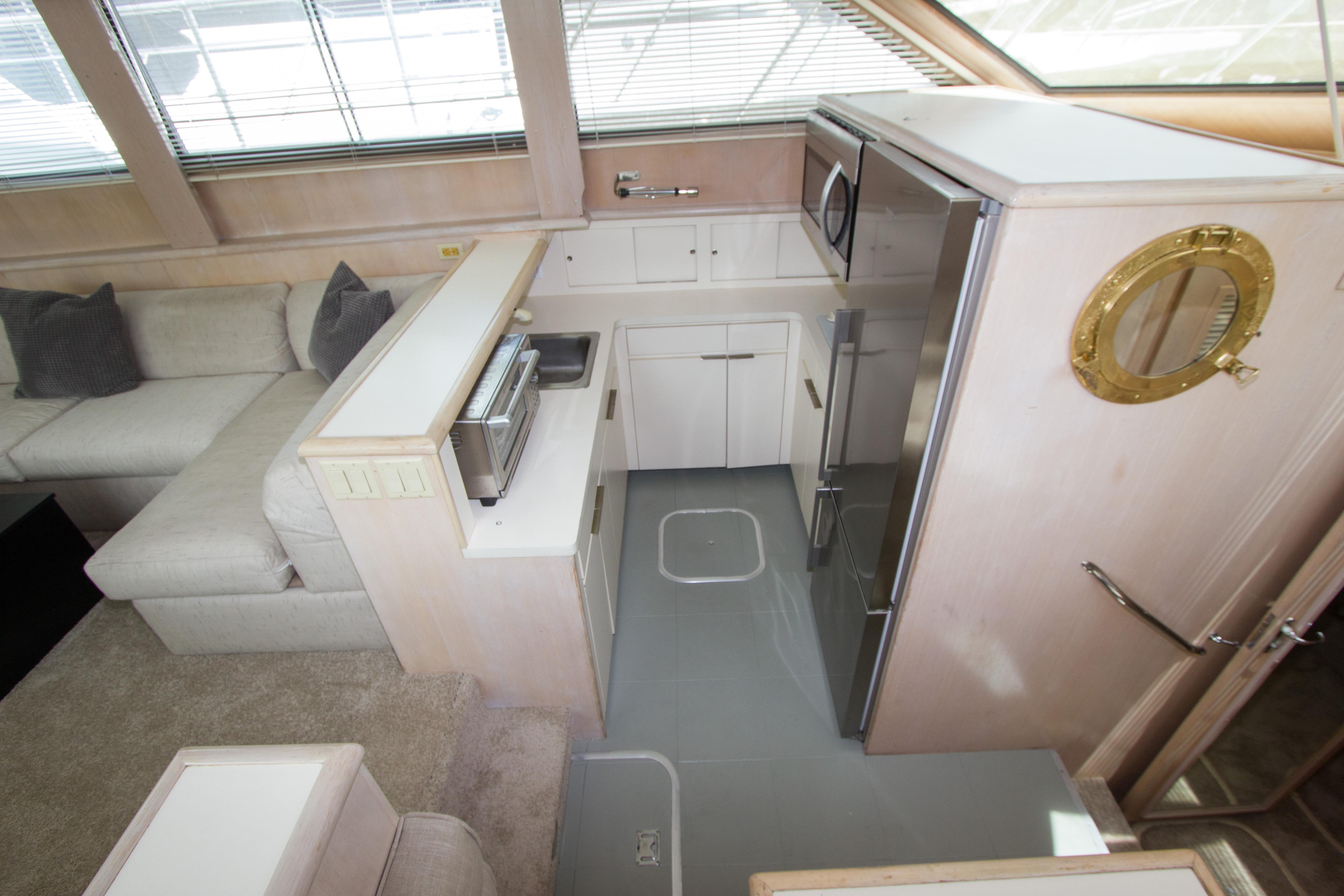 Interior of 1994 Hatteras 52 Cockpit Motor Yacht with modern kitchen and cozy seating area.