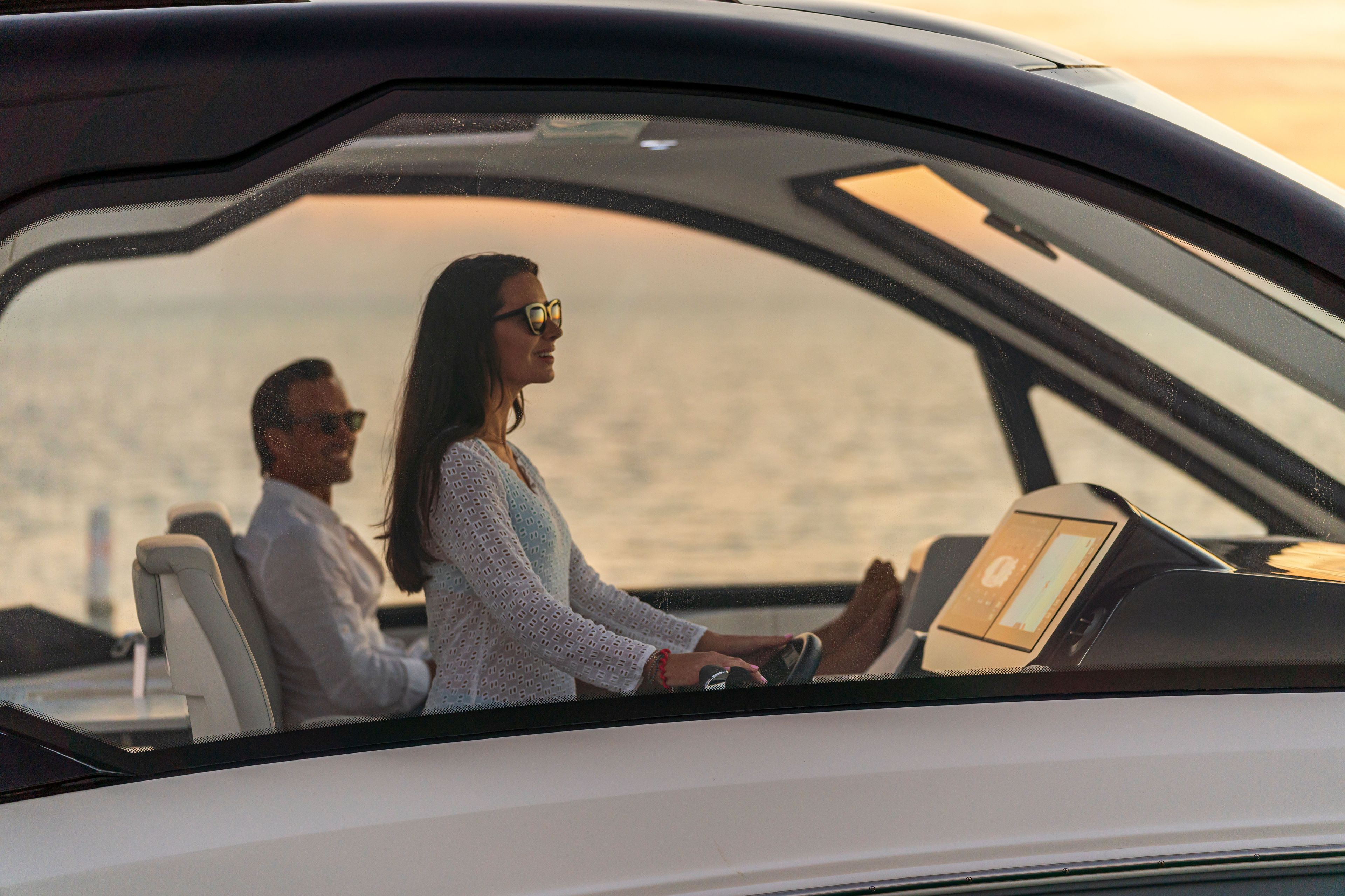 Two people enjoy the view from the Sea Ray Sundancer 370 Outboard at sunset.