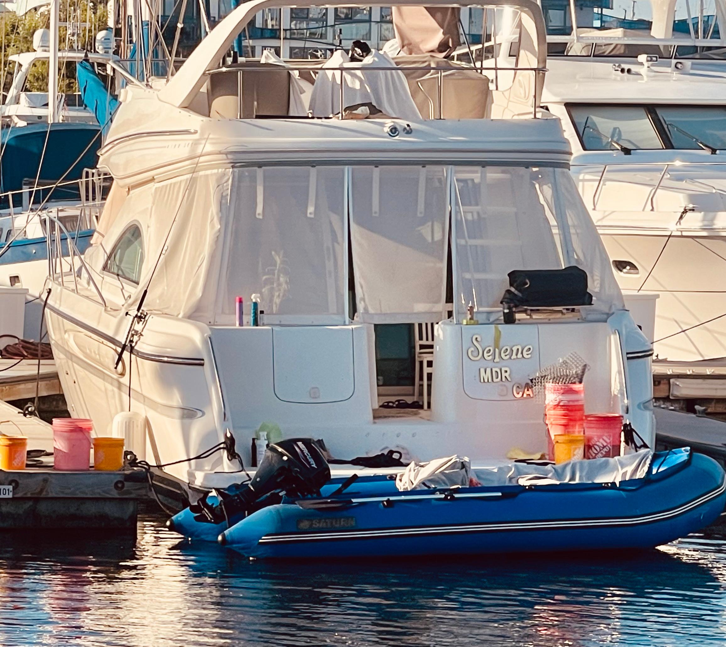 1998 Maxum 4100 SCA yacht docked with inflatable boat and supplies.