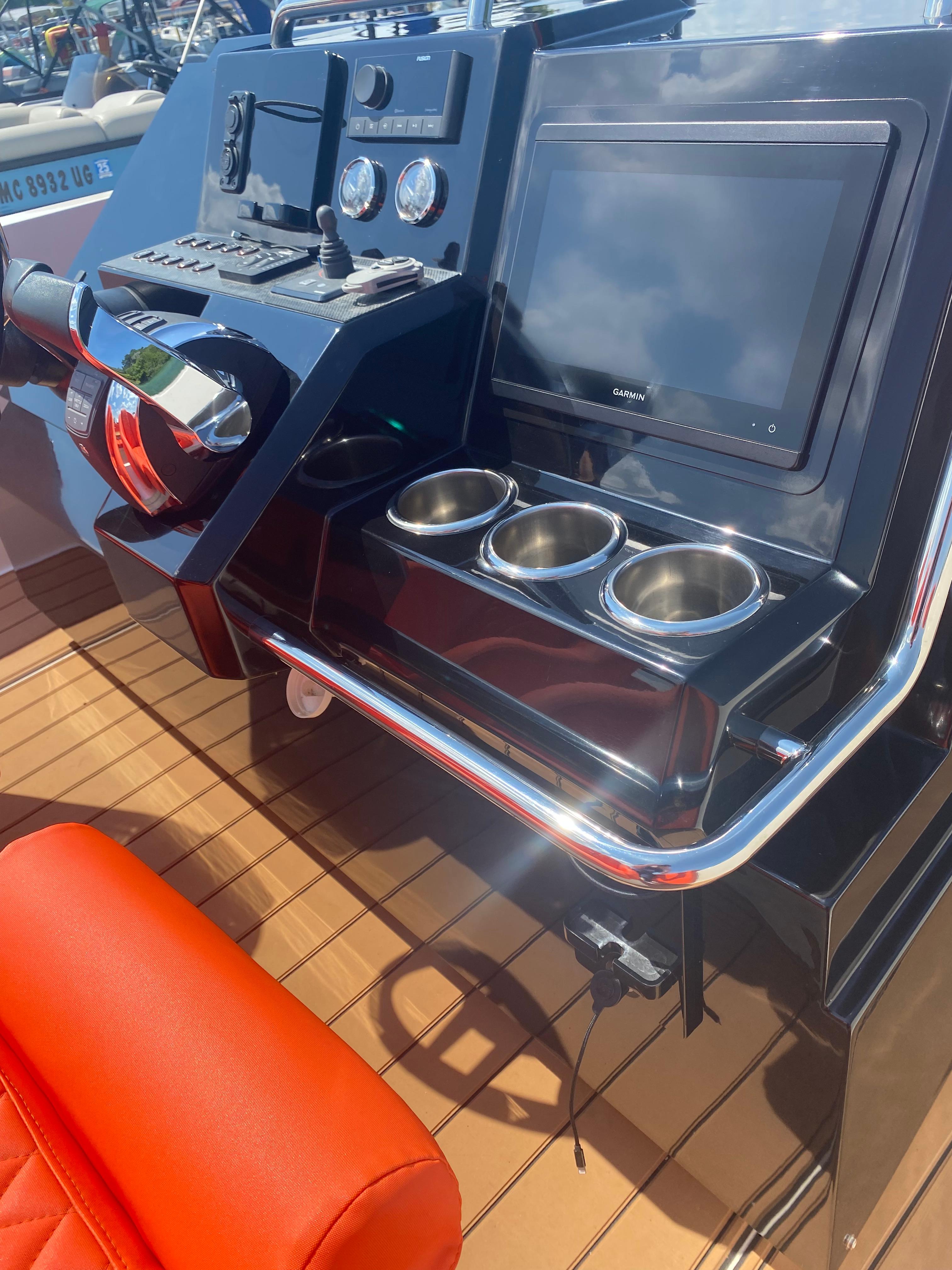 Control panel of 2020 De Antonio Yachts D 28 with navigation screen and cup holders.