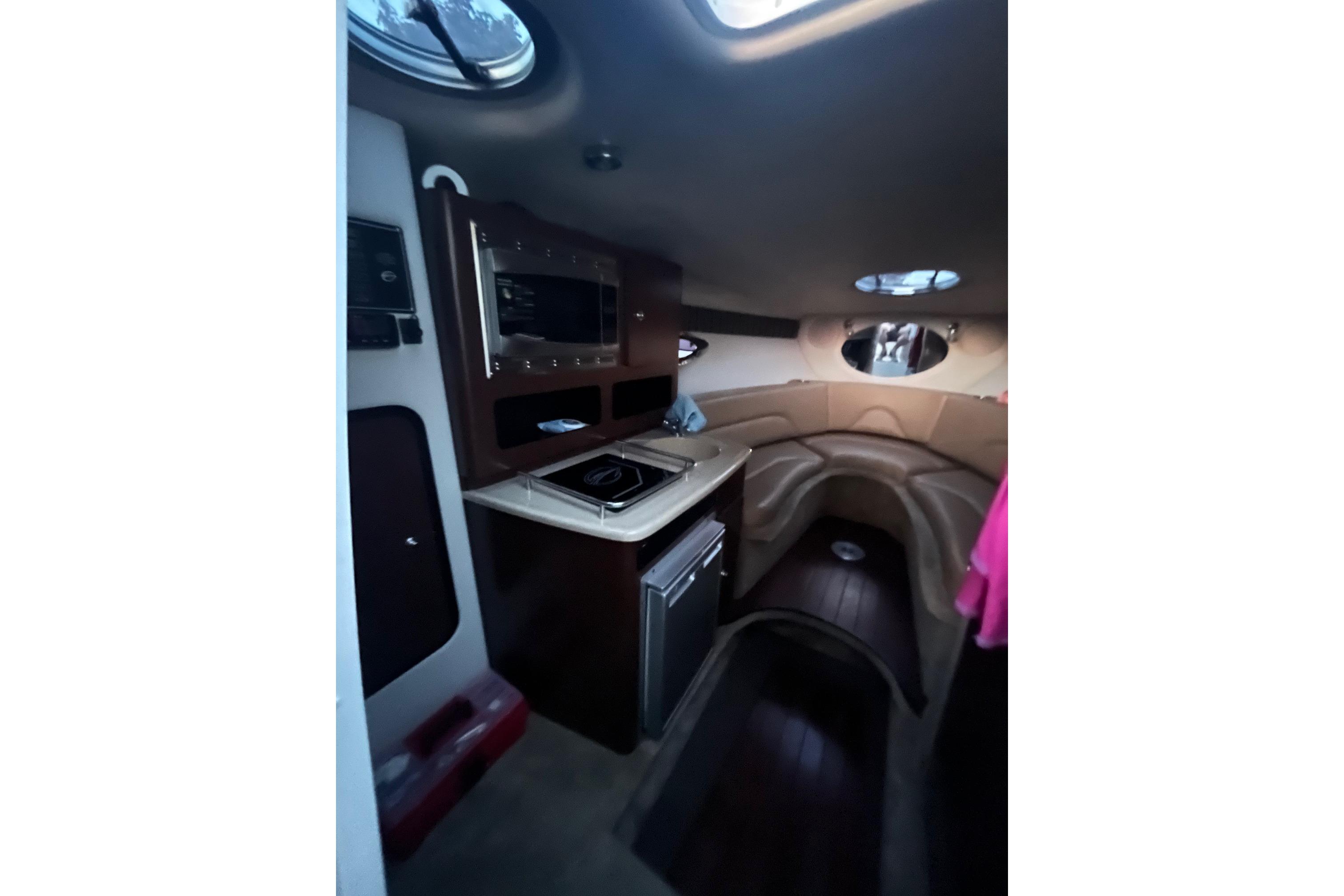 Interior of 2016 Crownline 264 CR boat with kitchenette and seating area.