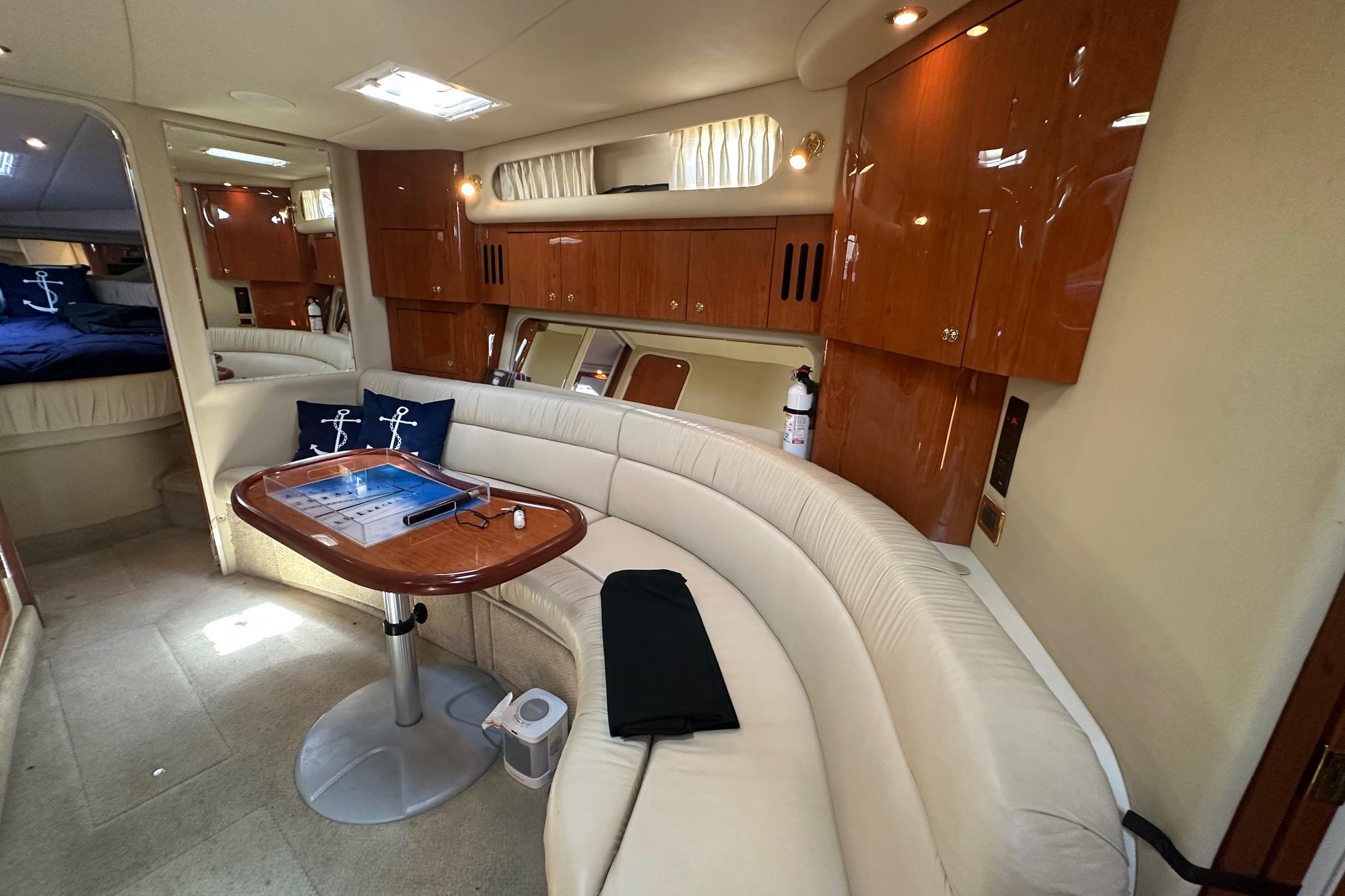 Luxurious interior of a 2001 Sea Ray 410 Sundancer yacht with elegant seating and wooden cabinetry.