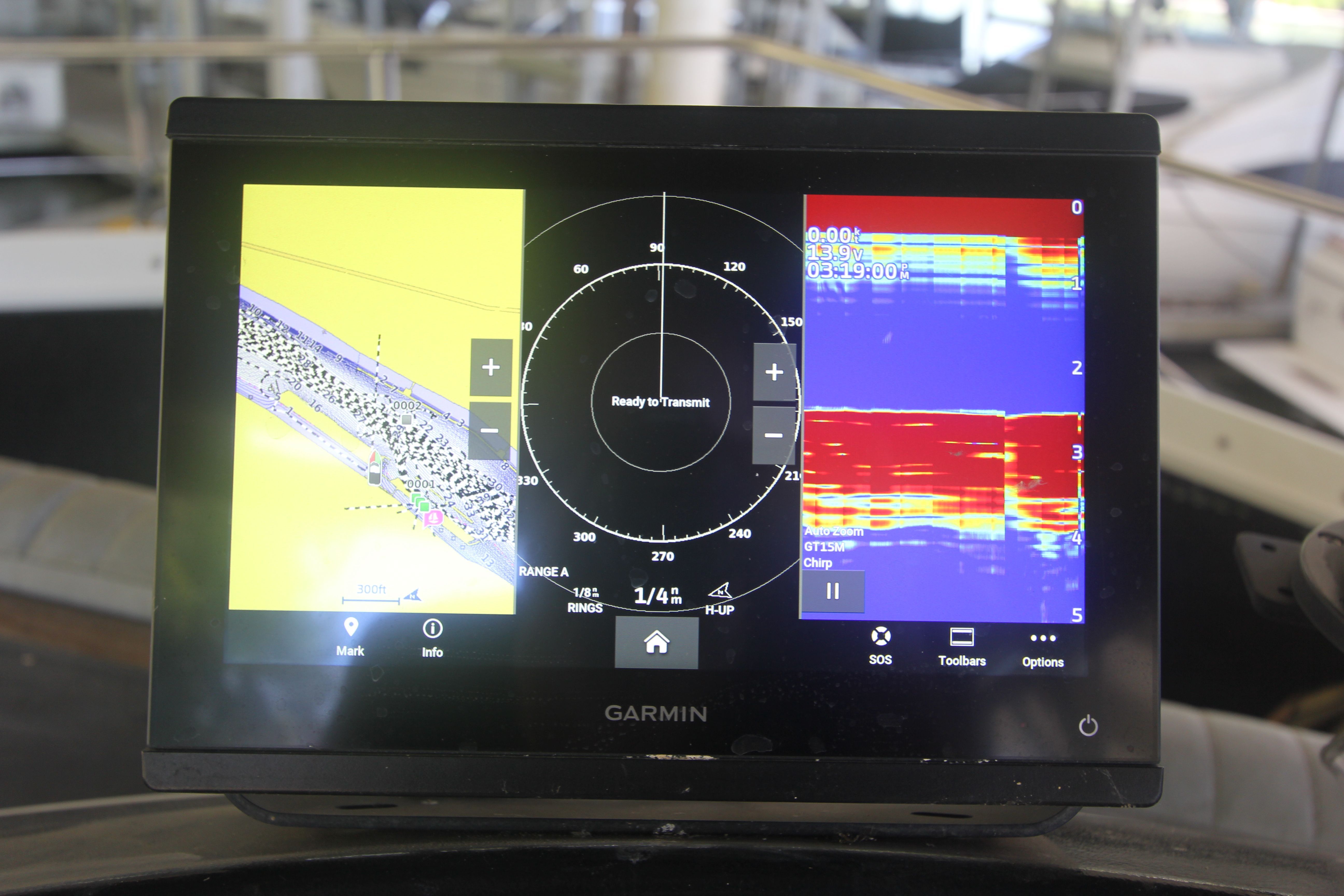 A Garmin navigation system displays sonar and chart data, surrounded by boat interior.