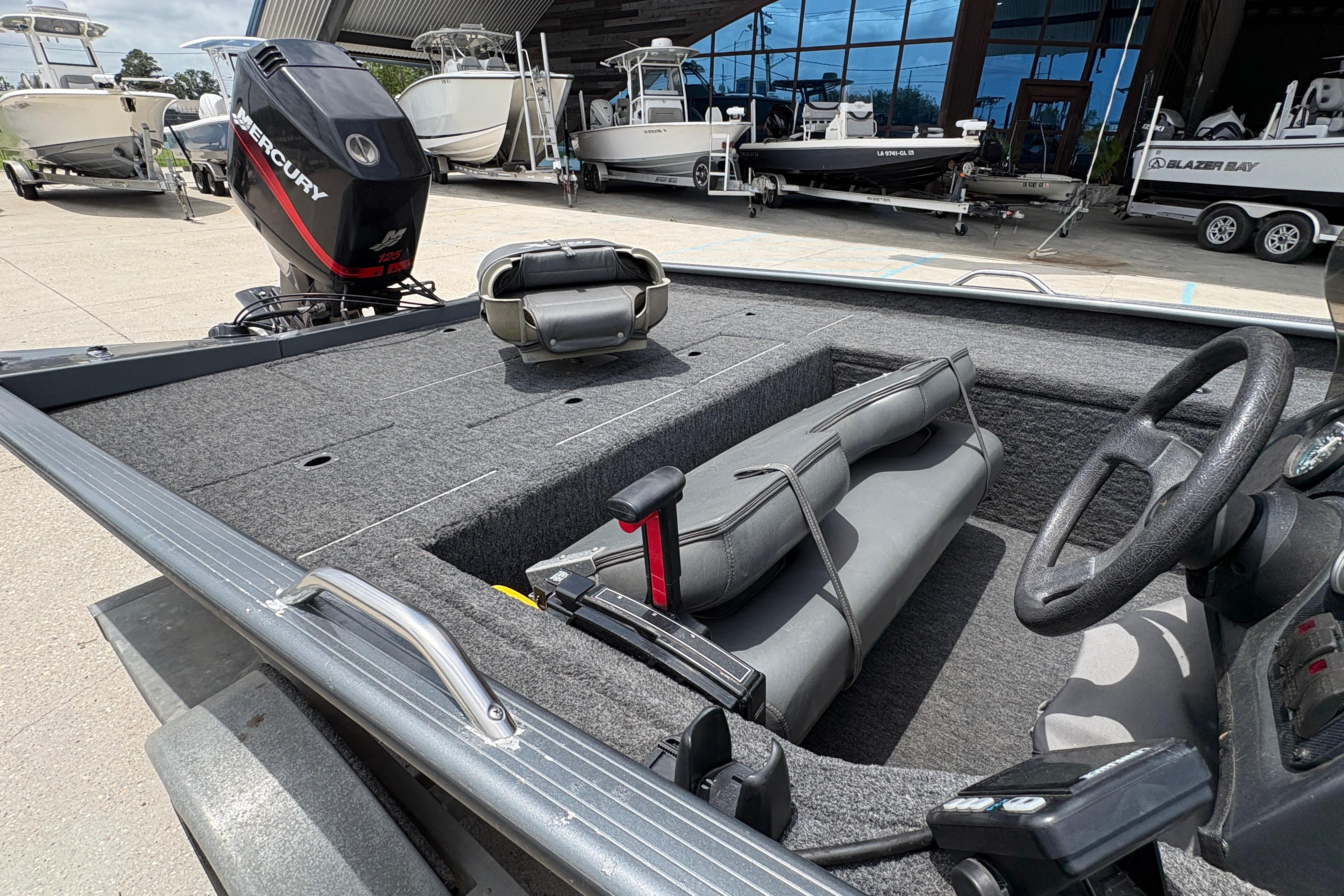 2000 Xpress X18 boat interior with Mercury engine, parked among other boats.
