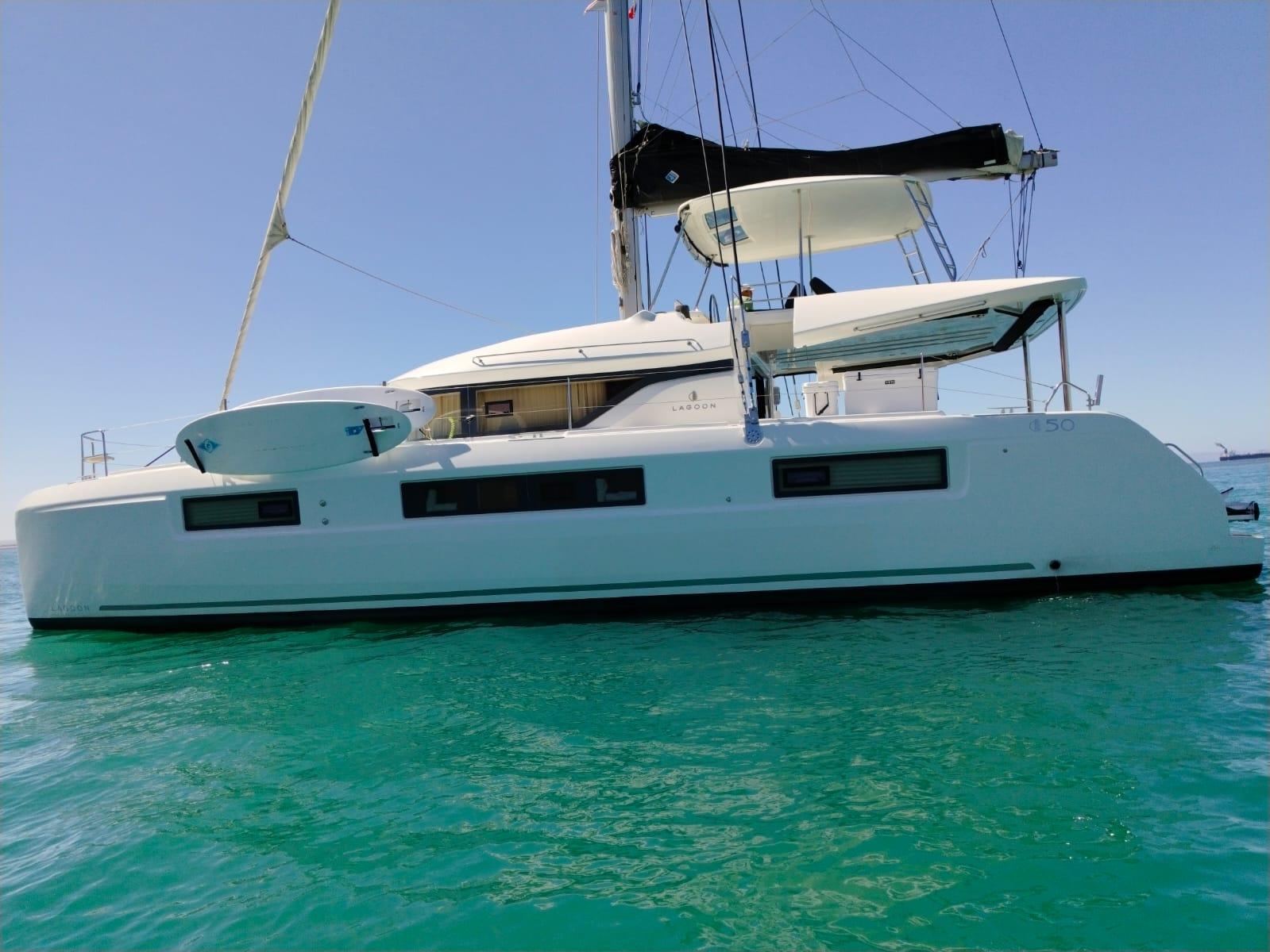 2018 Lagoon 50 catamaran sailing on clear turquoise water.