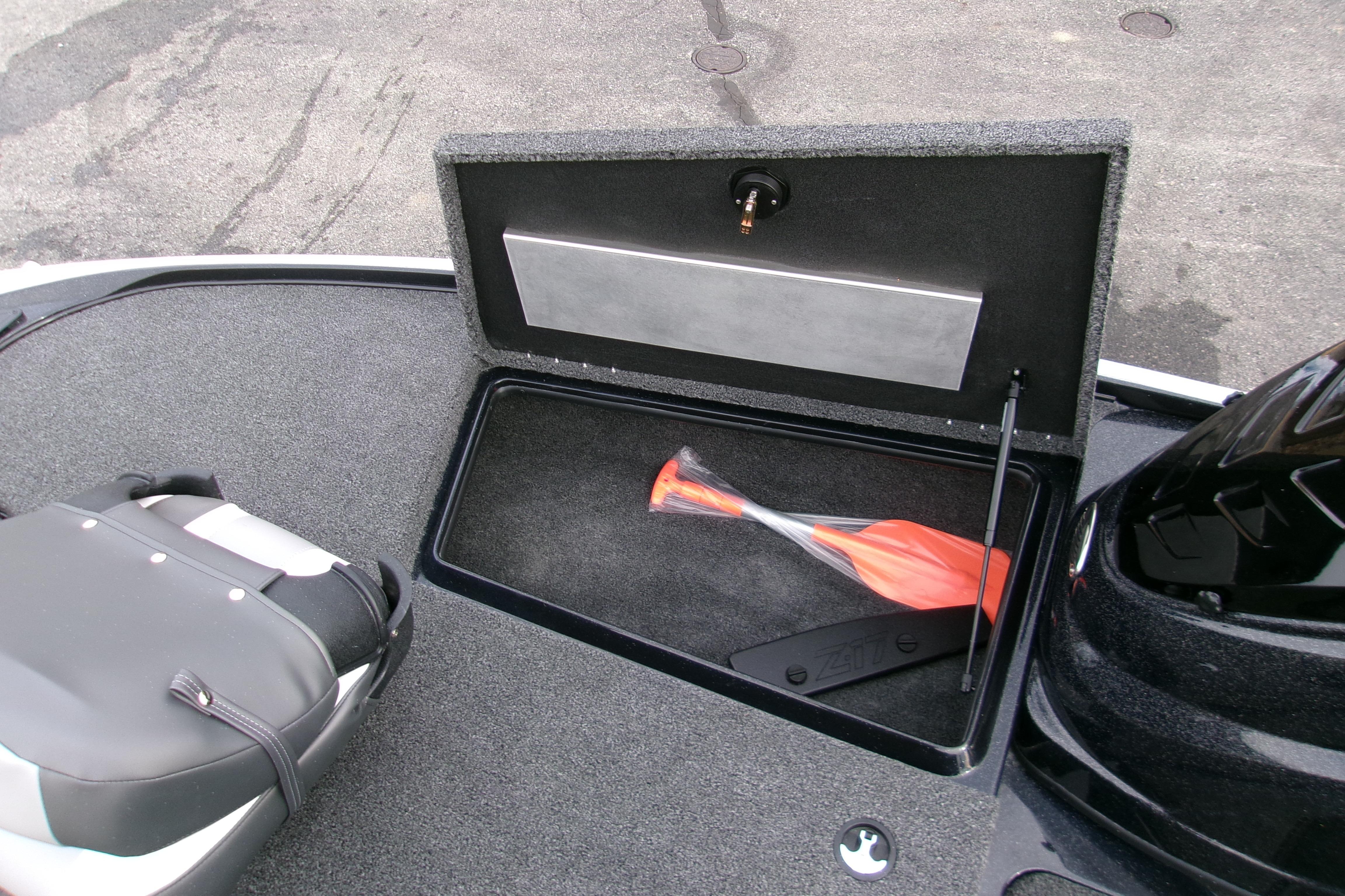 Open storage compartment in 2026 Nitro Z17 boat with paddle inside.
