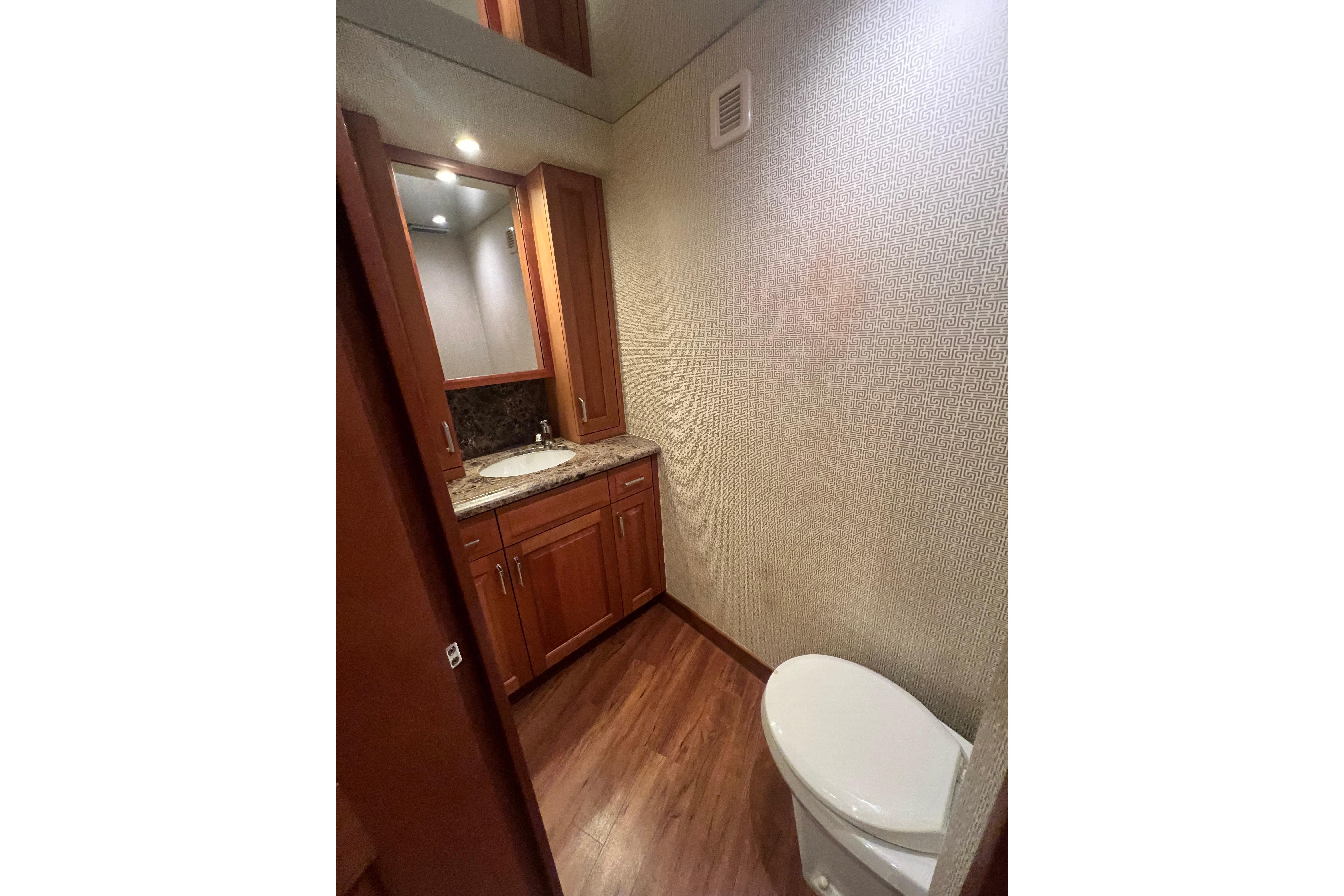 Luxurious bathroom interior of 2013 Hatteras GT63 yacht with wooden cabinetry and modern fixtures.