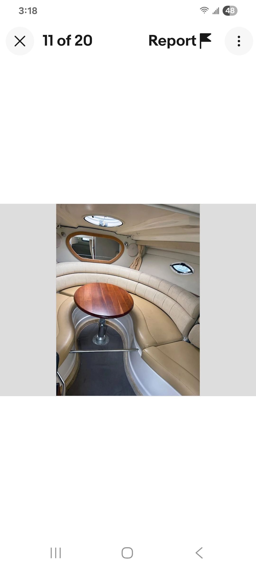 Interior of a Monterey 290 Cruiser with a round seating area and wooden table.