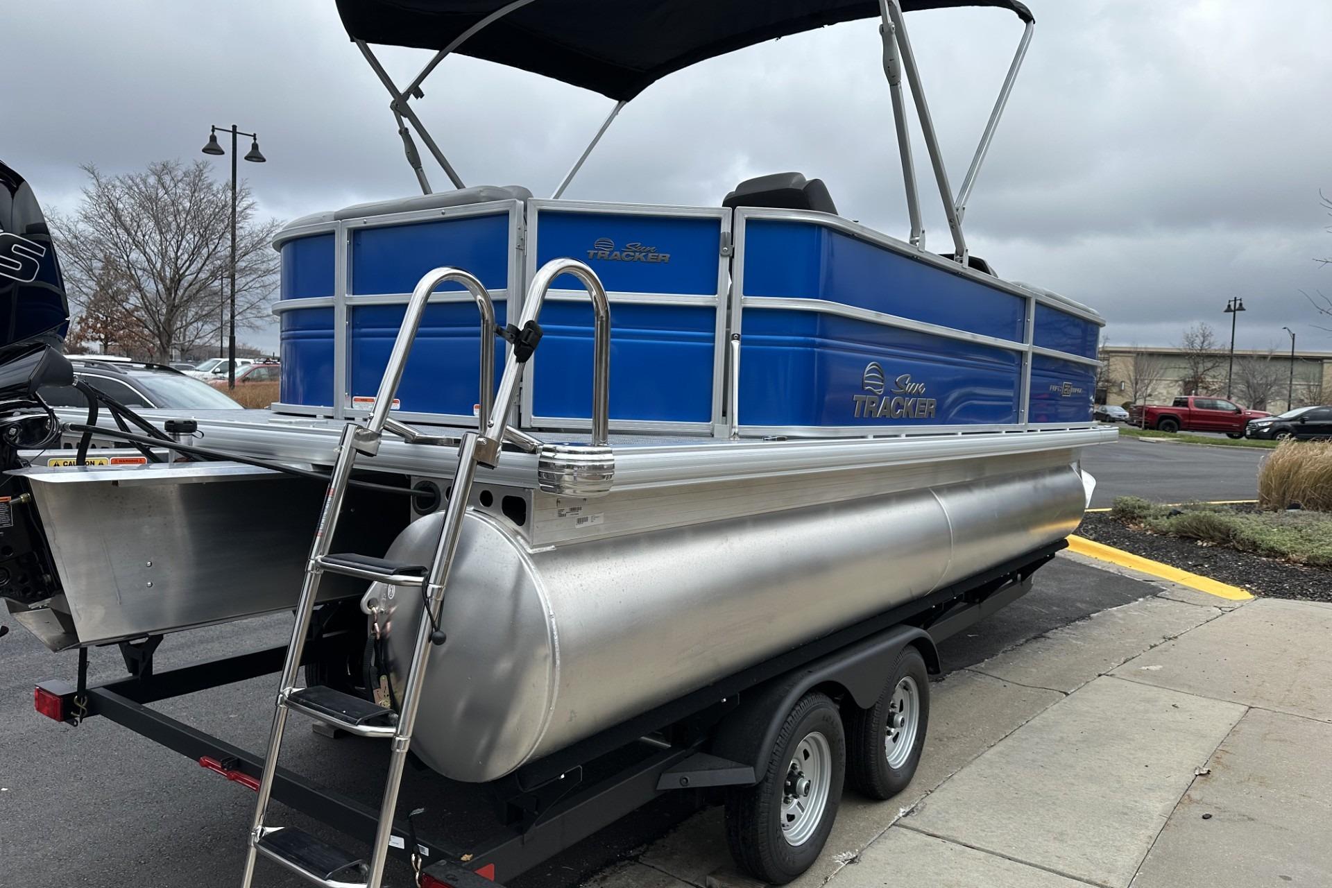 2026 Sun Tracker Party Barge 20 DLX pontoon boat on trailer, parked outdoors.