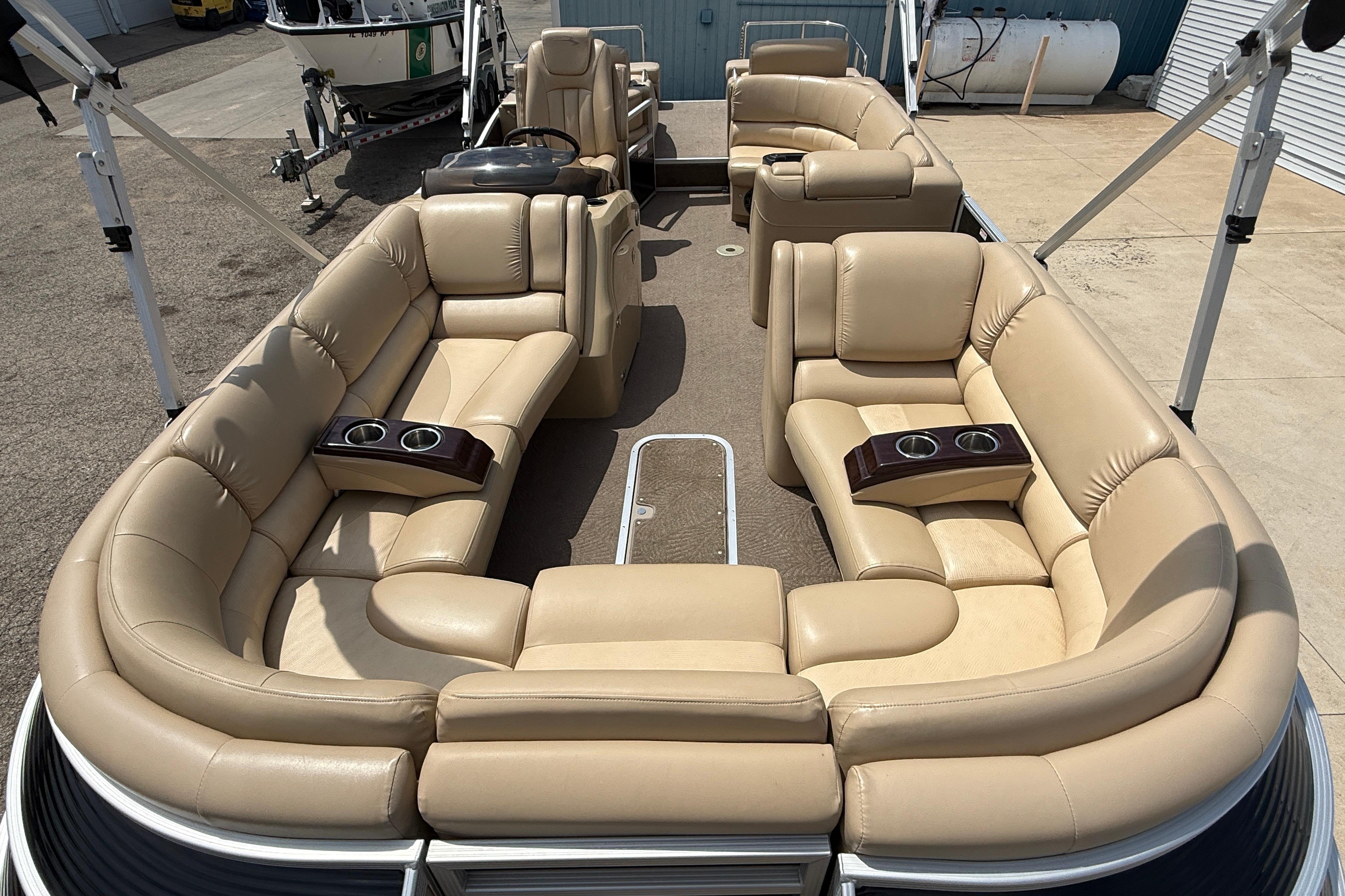 Luxurious seating on 2011 Bennington 2575QCW I/O pontoon boat with cup holders.