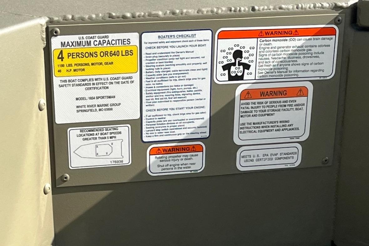 Safety and capacity labels on 2026 Tracker Grizzly 1654 T Sportsman boat.